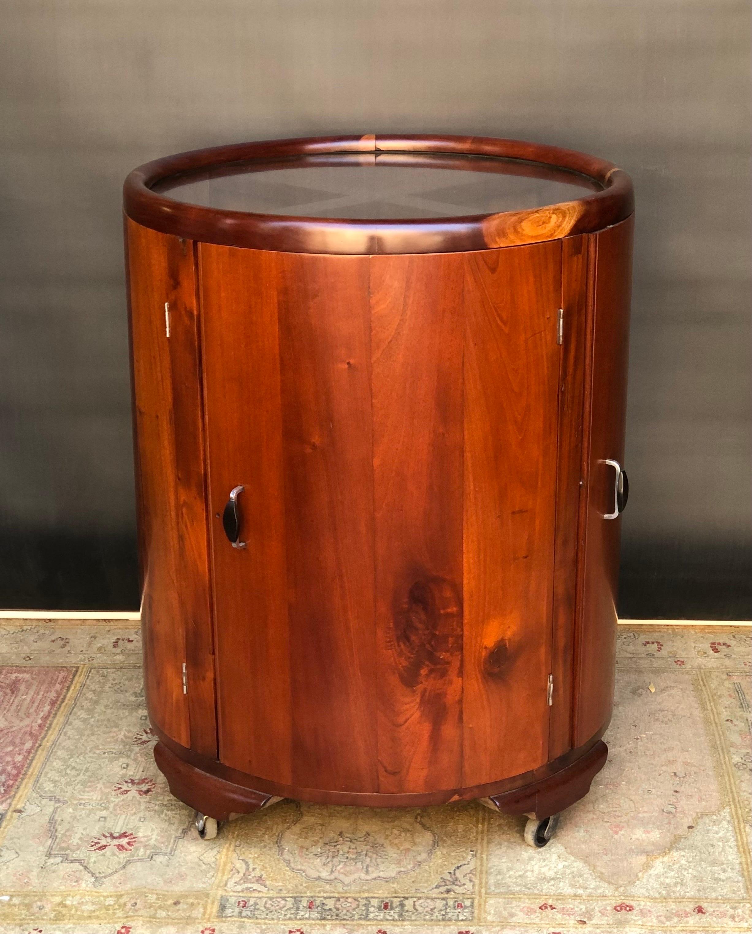 This Rare Jamaican Art Deco. Round, Four Door Mahogany Bar / Cocktail Cabinet was designed and handmade by Burnett Webster (1909–1992) in Kingston, Jamaica. The Jamaican Art Deco Cocktail Cabinet is constructed using spectacularly figured solid