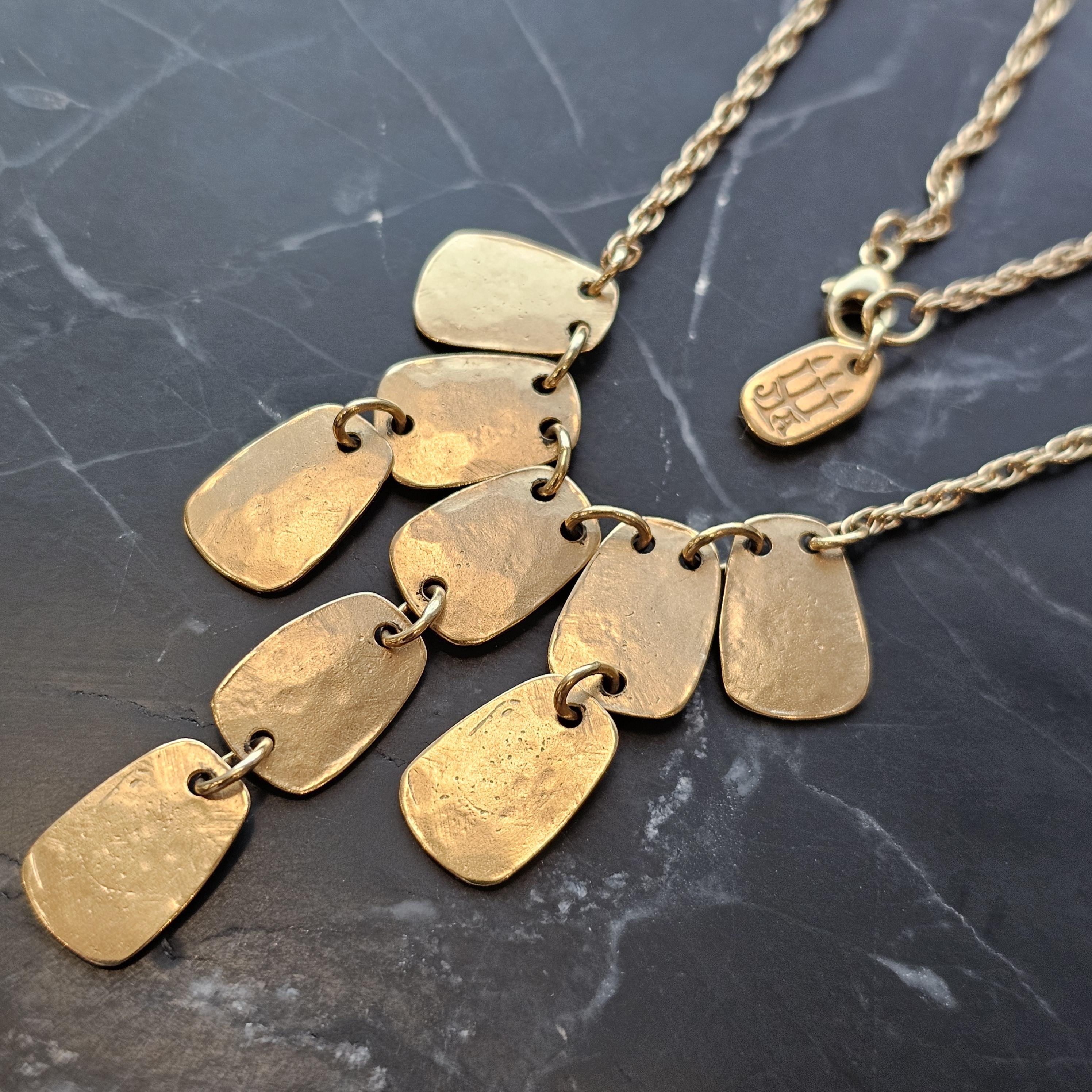 This exquisite James Avery necklace features a 14k yellow gold chain, measuring 16.75 inches long. The bib design showcases a series of textured gold pendants, creating a striking visual effect. Perfect for those seeking a distinctive accessory to