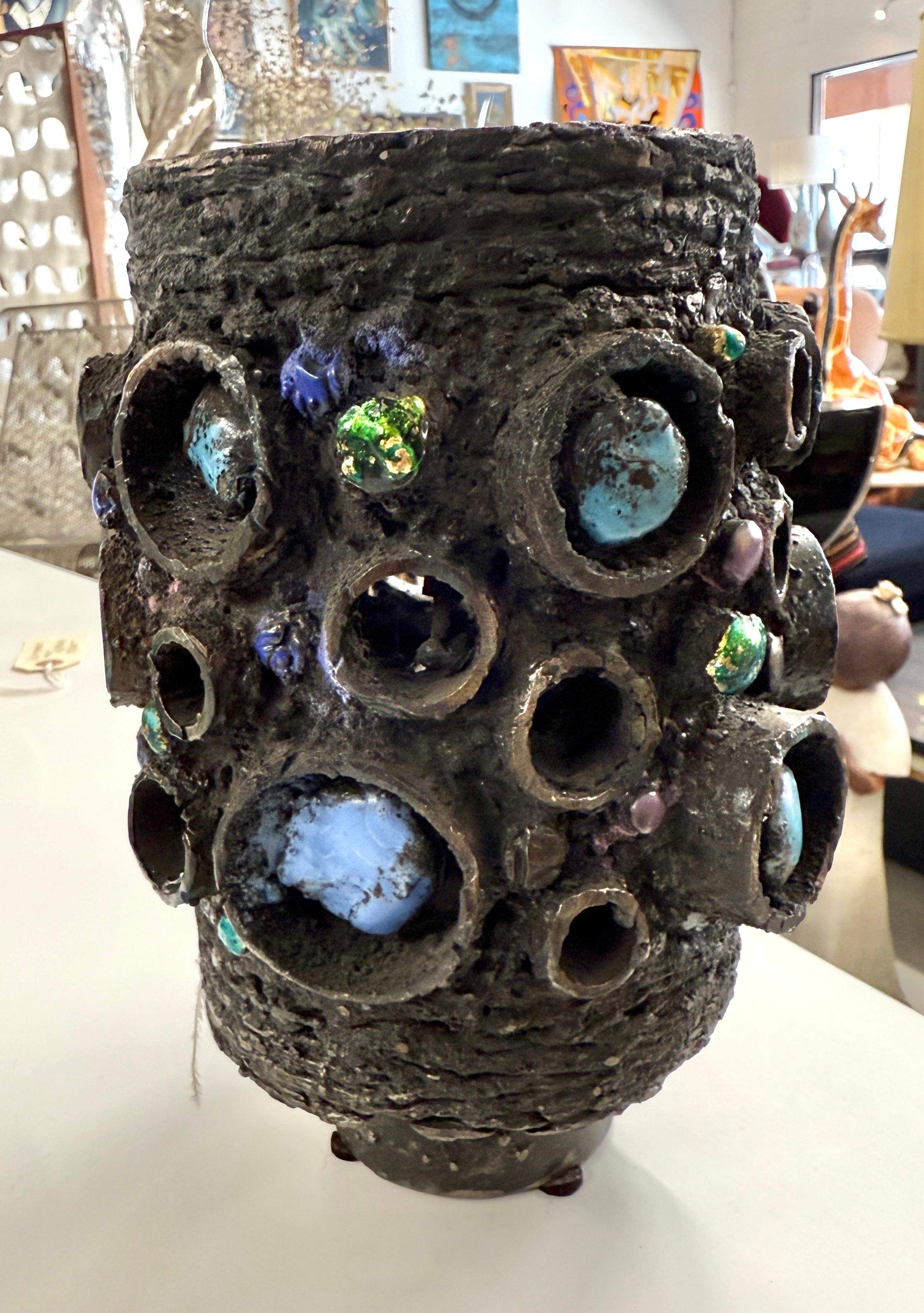 Un acier brutal et saisissant, découpé au chalumeau,  et une sculpture en verre émaillé du célèbre artiste de Des Moines, dans l'Iowa, James Bearden. La pièce présente de magnifiques reflets en émail de verre coloré. 
Extrait du site web de