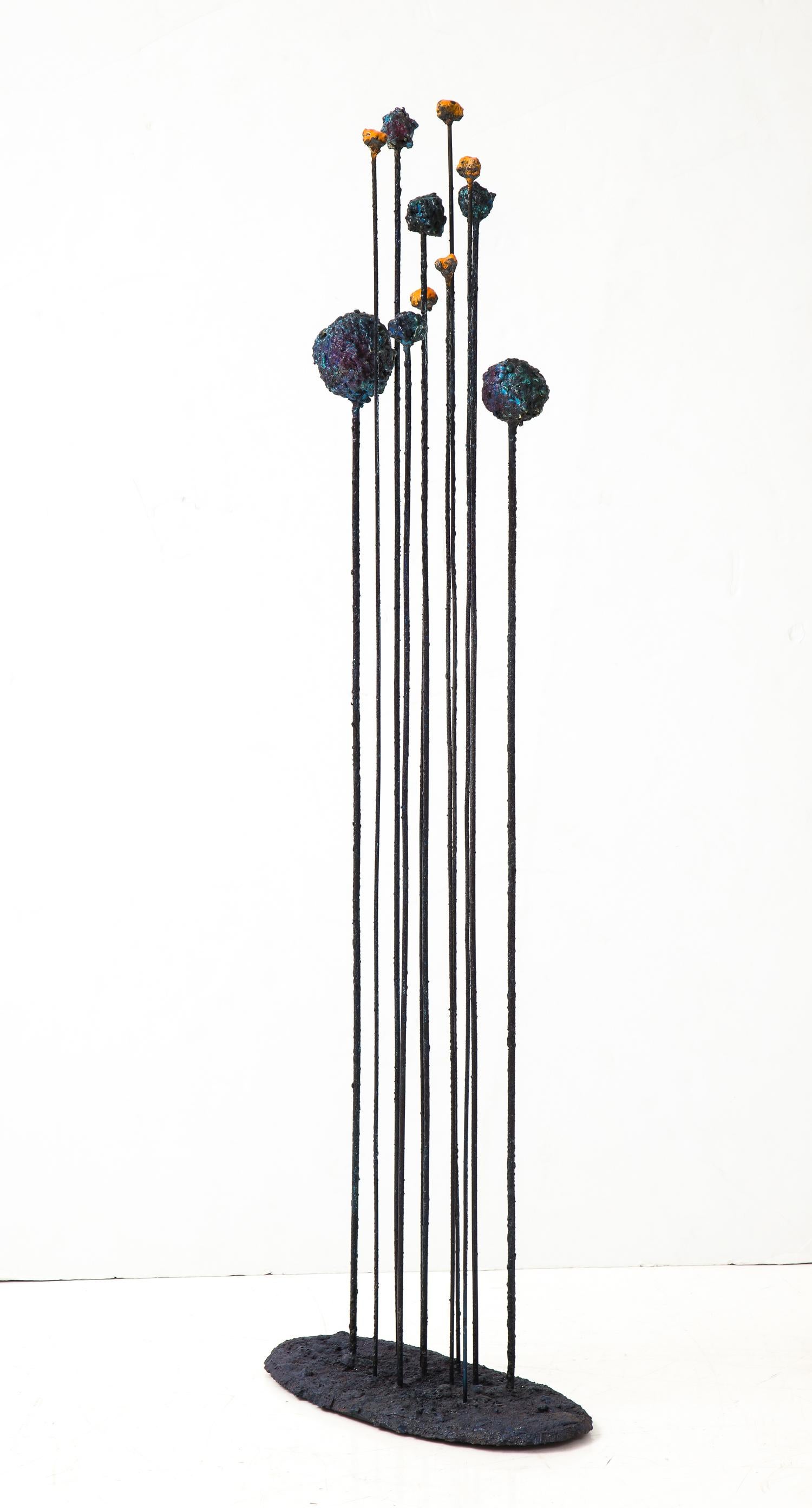 Sonic sculpture of torch-cut steel fused with glass enamel titled “Meteor Storm” by American artist James Bearden. The array of iridescent, molten-looking celestial shapes surmounting slender rods has the aspect of a cosmic event; set in motion with