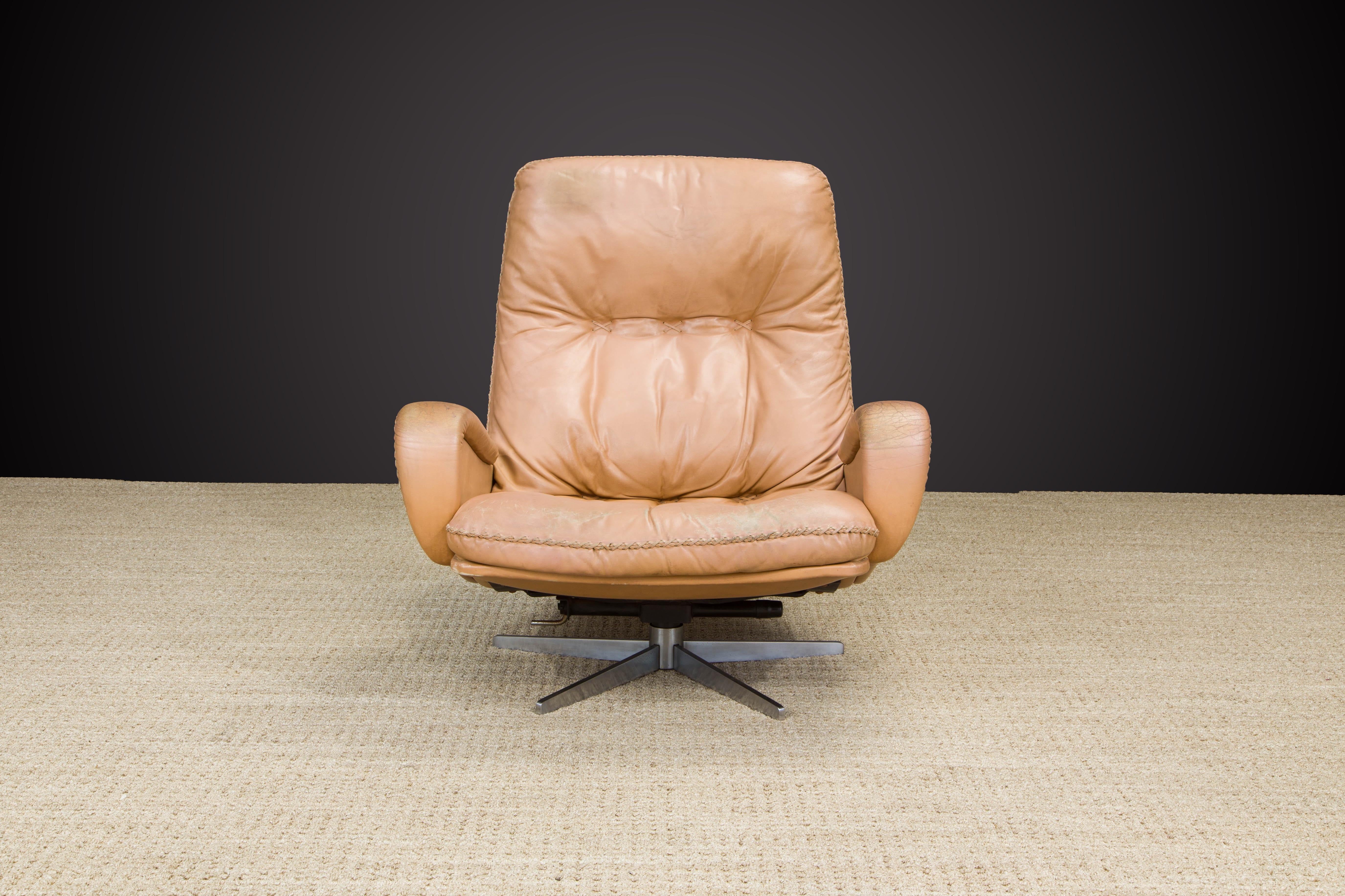 A rare and incredibly laid-back comfortable De Sede S 231 James Bond high-back swivel lounge armchair in an attractive lightly distressed tan leather with thick leather stitching similar to a baseball glove, designed and produced in the 1960s in