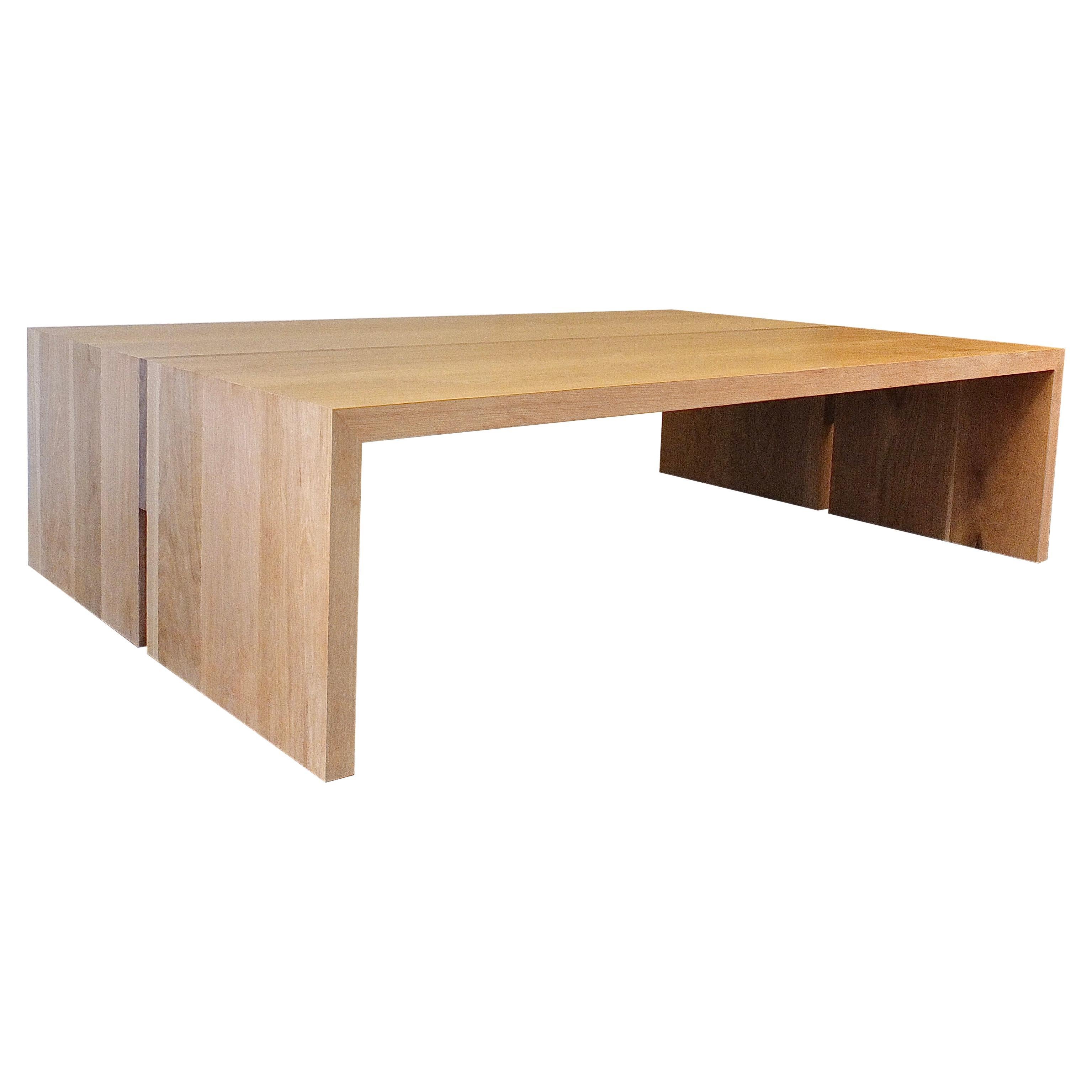 This custom coffee table is hand-made in the United States with all hardwood construction. It features a modern rectangle waterfall design with a solid white oak body and a minimalist walnut inlay detail. The inlay ends adding a unique lightness to
