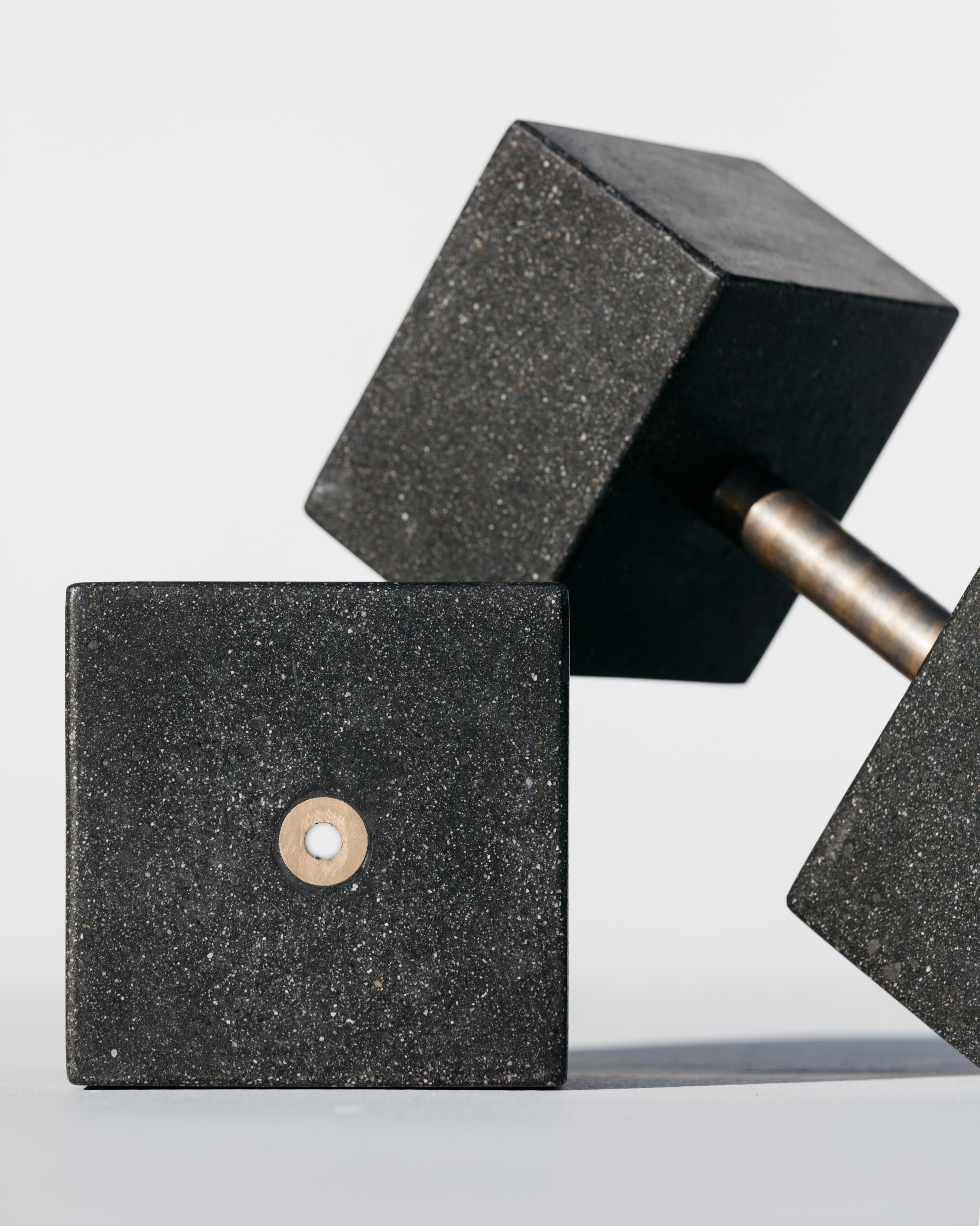 When concrete and bronze come together, it is a marriage of powerful aesthetic elements. Each weight is constructed of reinforced concrete, polished and sealed to a smooth, unique lustre. The bronze bar is exposed at the end of each block for a