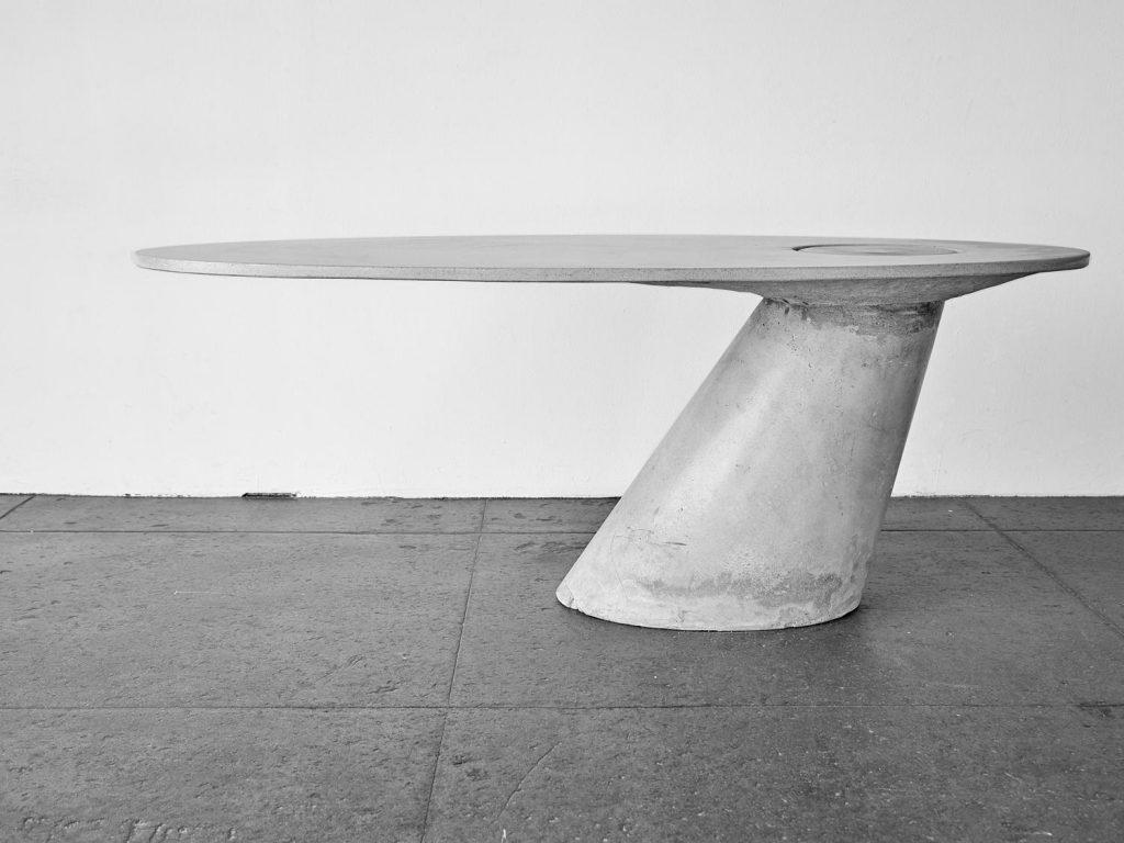 Dieser Tisch ist ein Spiel mit dem Gleichgewicht und besteht vollständig aus zwei Betonteilen. Die Tischplatte wird von einem Bein getragen, während die beiden durch die Schwerkraft miteinander verbunden sind und einrasten. Ihre Ausgeglichenheit ist