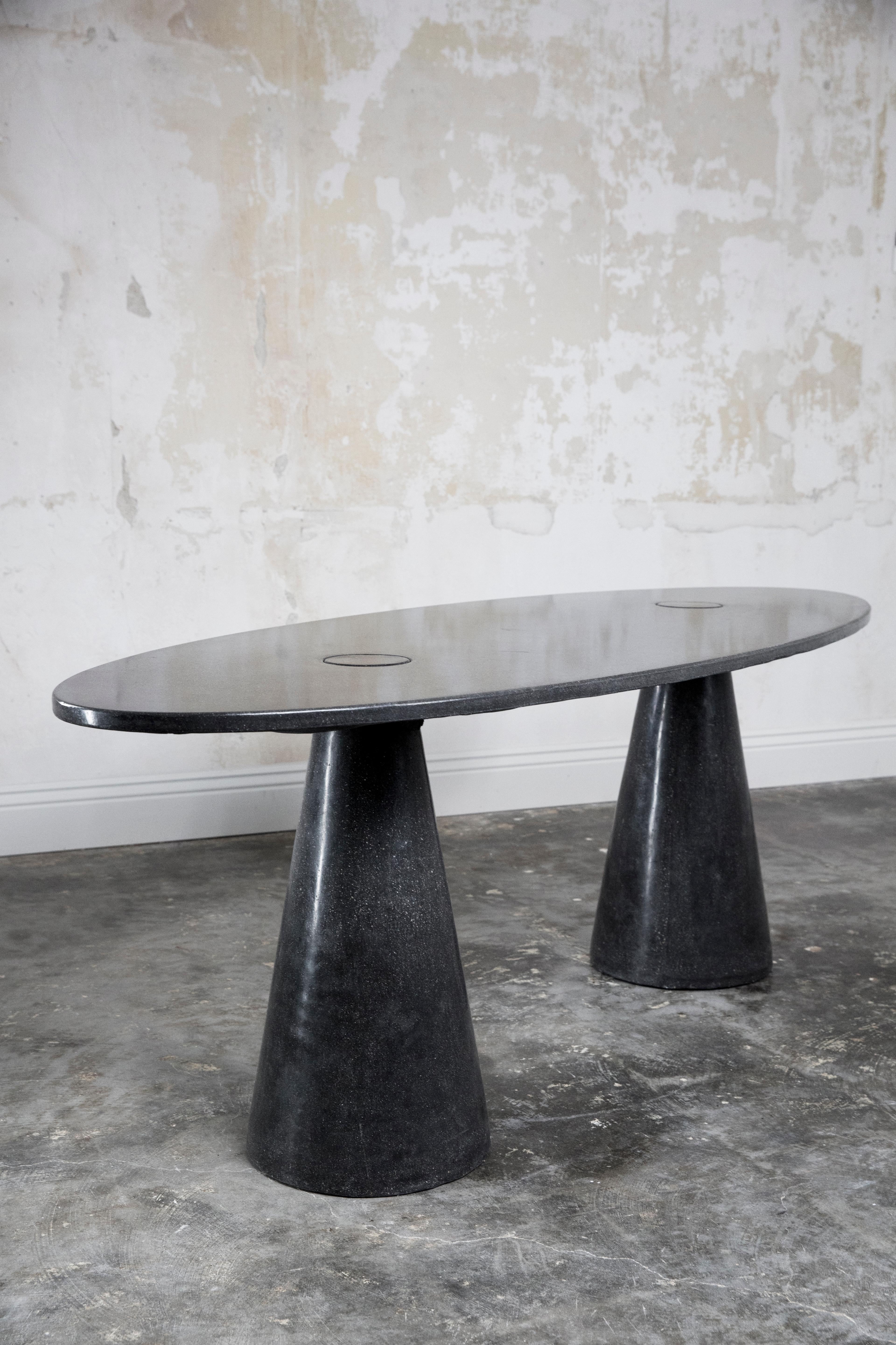 The oval double-locking table in concrete is an ode to the shapes of Mangiarotti. The table consists of three pieces; top and bases lock together by gravity. There is no hidden support or attachment. Tables are sealed with a unique finishing wax,