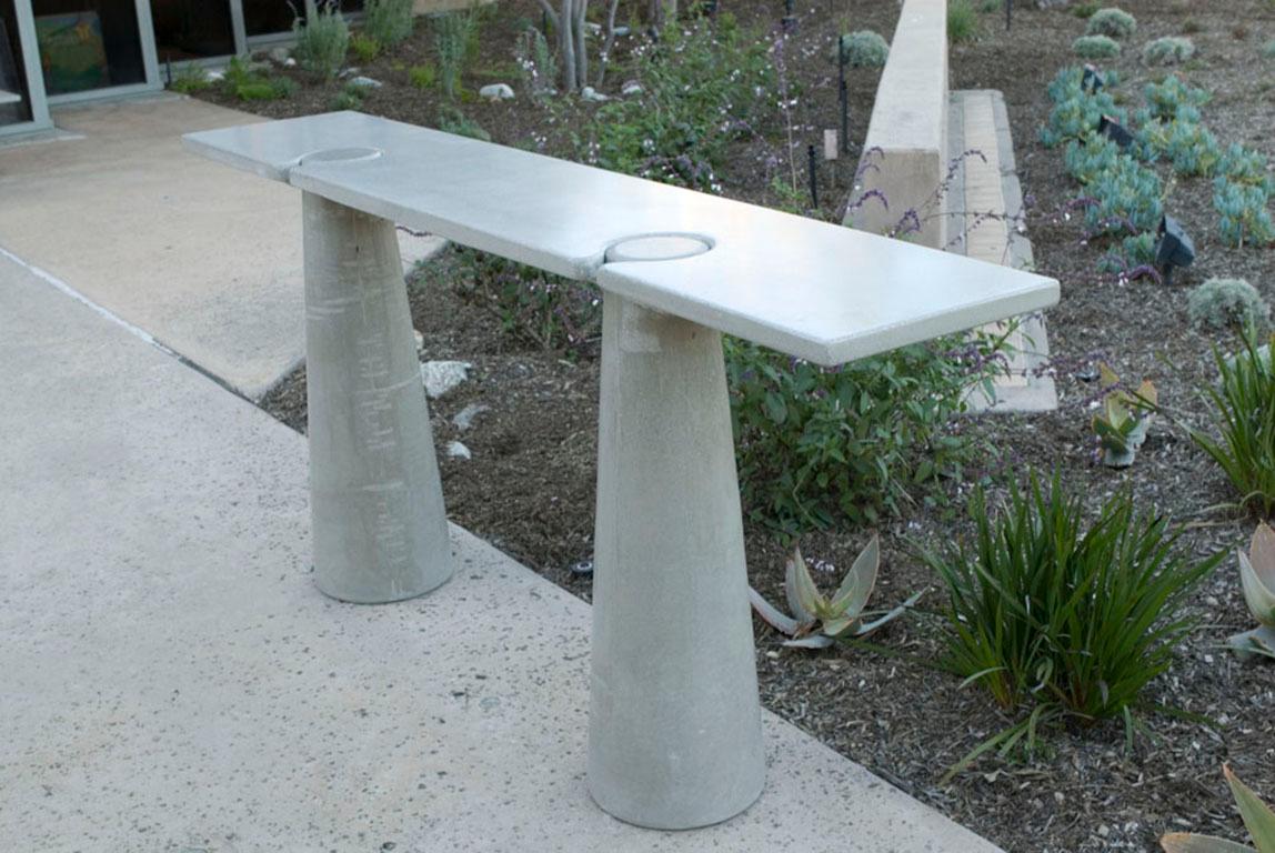 The tall locking console in concrete is an ode to the shapes of Mangiarotti. The table consists of three pieces; top and bases lock together by gravity. There is no hidden support or attachment. Tables are sealed with a unique finishing wax,