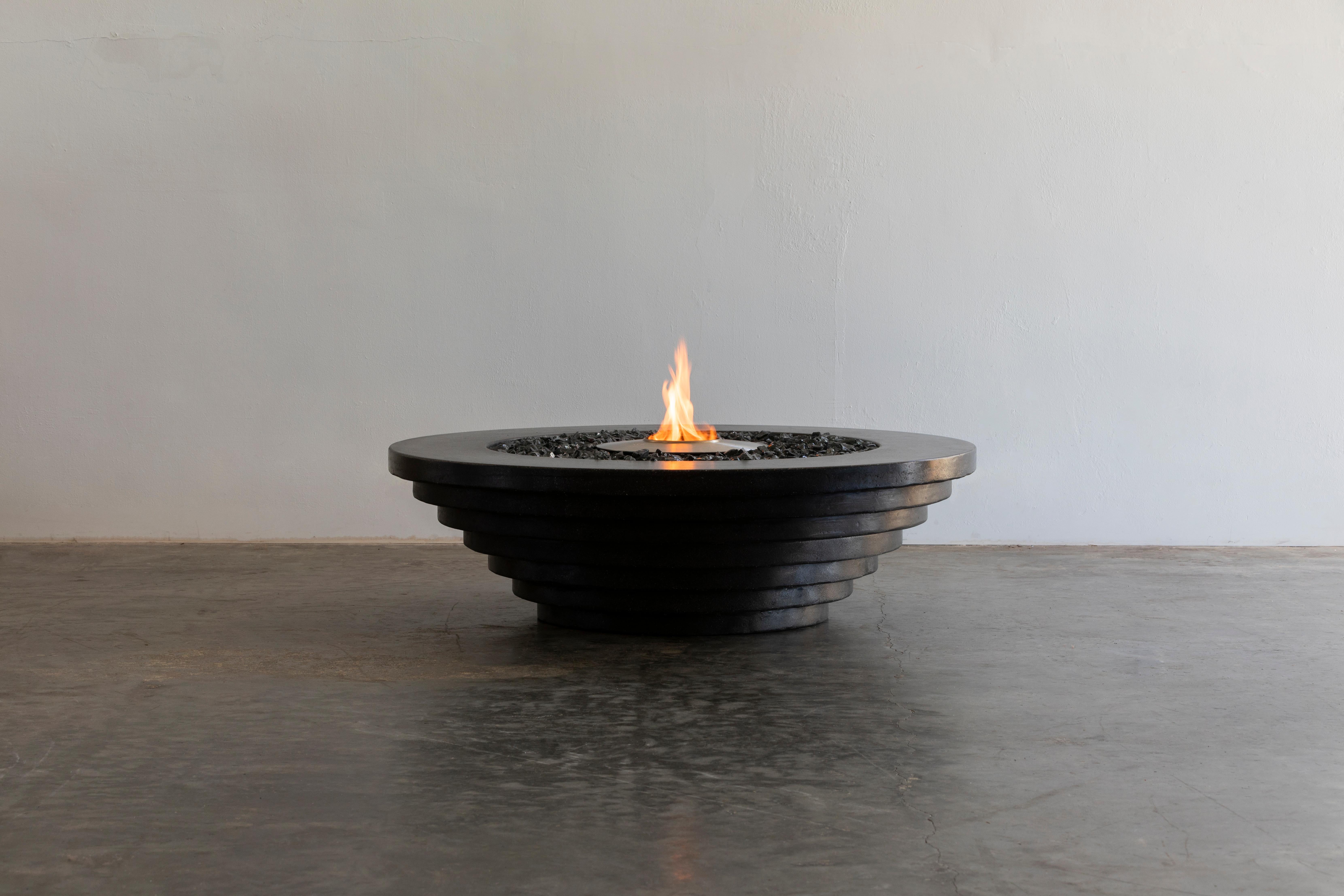 Der stufenförmige Feuertisch aus Beton von James de Wulf ist der dritte Entwurf einer Serie von drei verschiedenen Stilen. Beeinflusst durch die Geometrie von Scarpa, sitzt der Stepped Fire Table in abgestuften Kreisen mit einem oberen Durchmesser