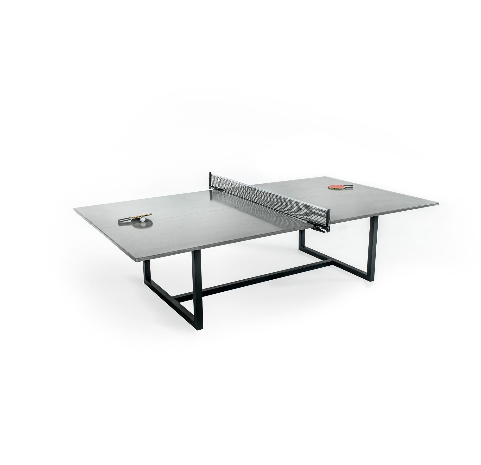 Contemporary concrete ping pong table with carbon fiber reinforcement and powder coated steel base. Regulation size with acid stained center line; doubles as a dining table. Comes with removable net. Suitable for indoor and outdoor use. Compliment