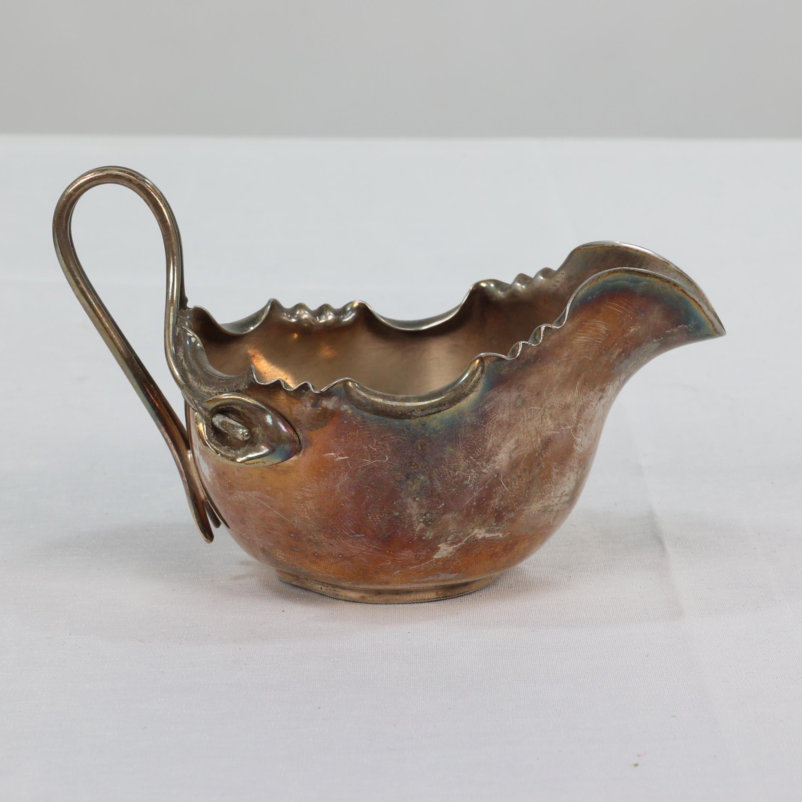 James Dixon, Dr C Dresser style of. An Aesthetic Movement silver-plated sugar bowl and milk jug, the jug with a trumpet style flower to the handle. H 5 x W 11 x D 11. 