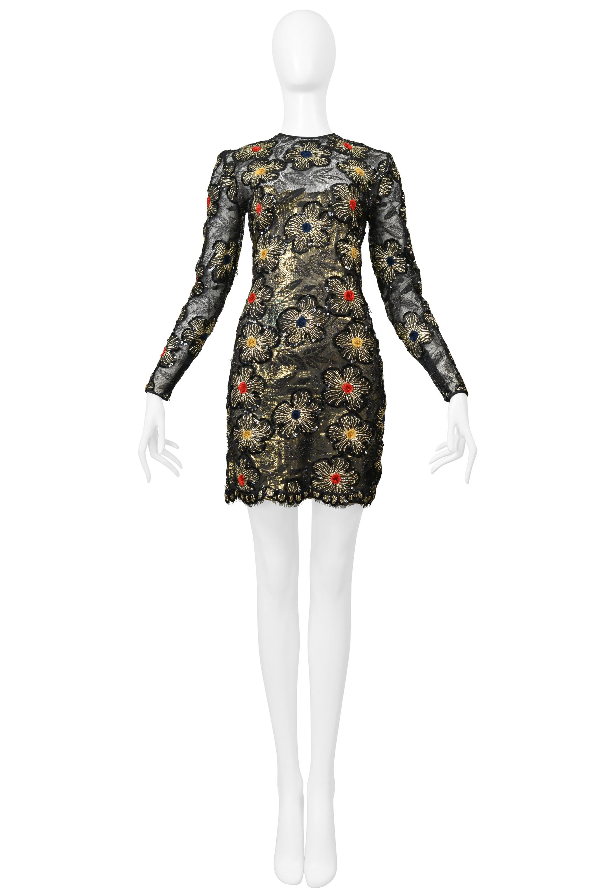 Resurrection is excited to present a vintage Galanos fancy black lace cocktail dress featuring a fitted body, gold starburst appliques with multicolor velvet pom-poms, zippers at cuffs, metallic gold lining, fancy trim hem, and hidden center back
