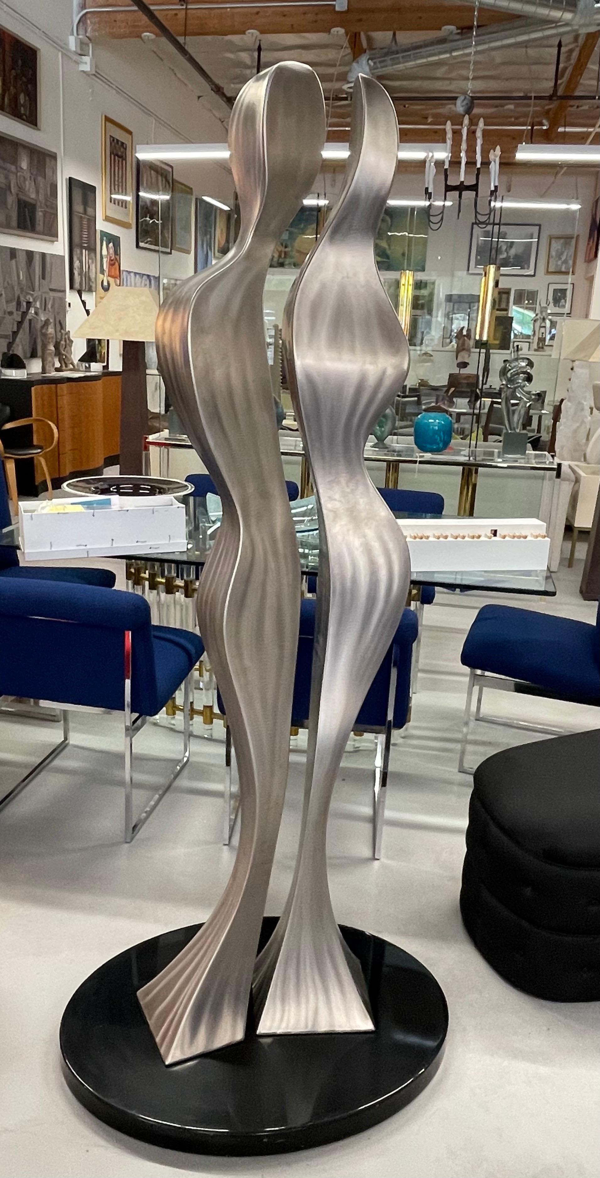 A large wonderful stainless steel sculpture titled Couples by the noted California artist James Hill. Signed and dated 2015. On a heavy polished painted steel oval base. The sculpture measures 72 inches tall, while the base measures 34x24 inches in