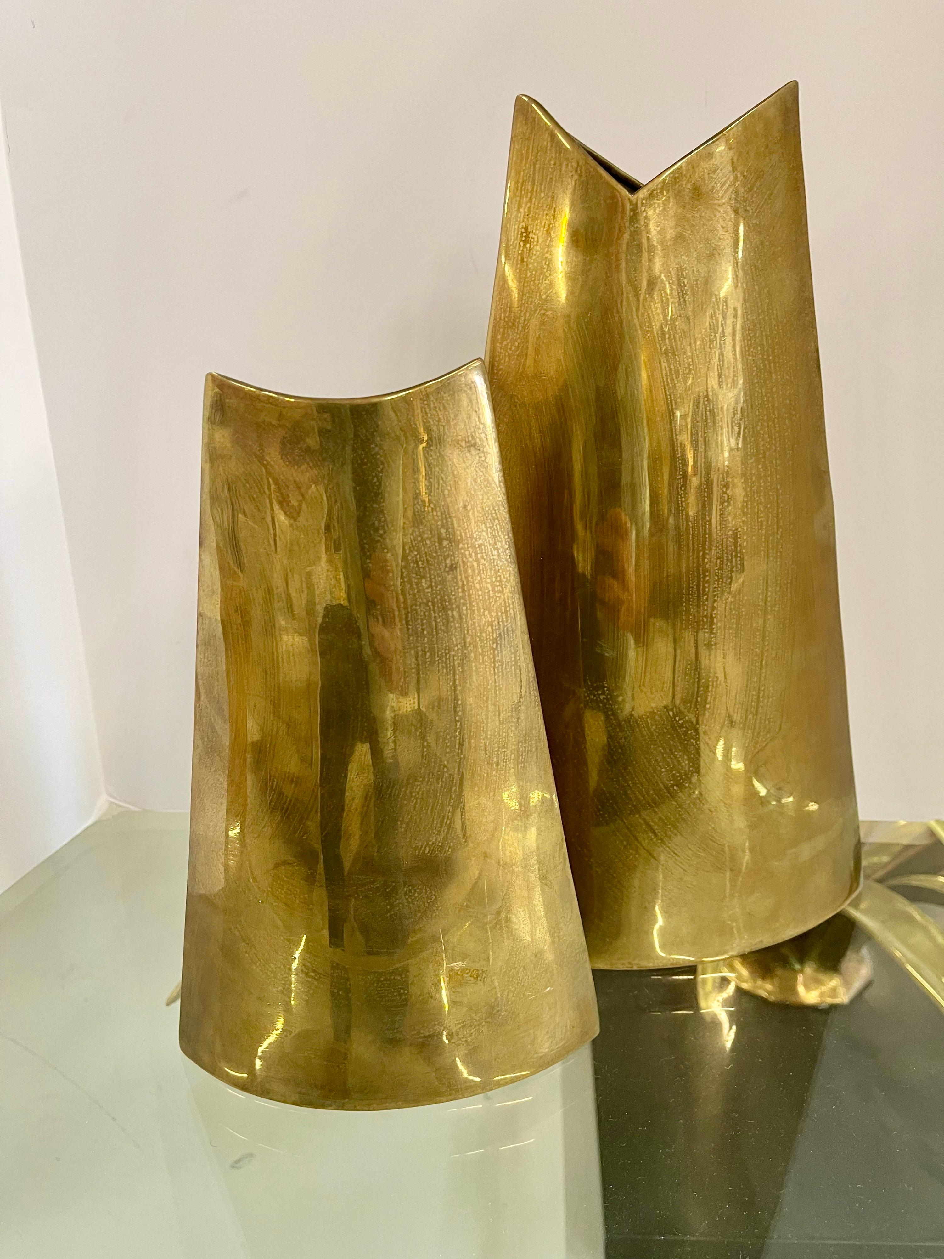Pair of James Johnston brass vases. Interesting shapes that complement each other. The taller one is approximately 13 1/2 inches tall. The smaller is 10 inches tall. Both are impressed on the base. These both have tarnishing and some marks and