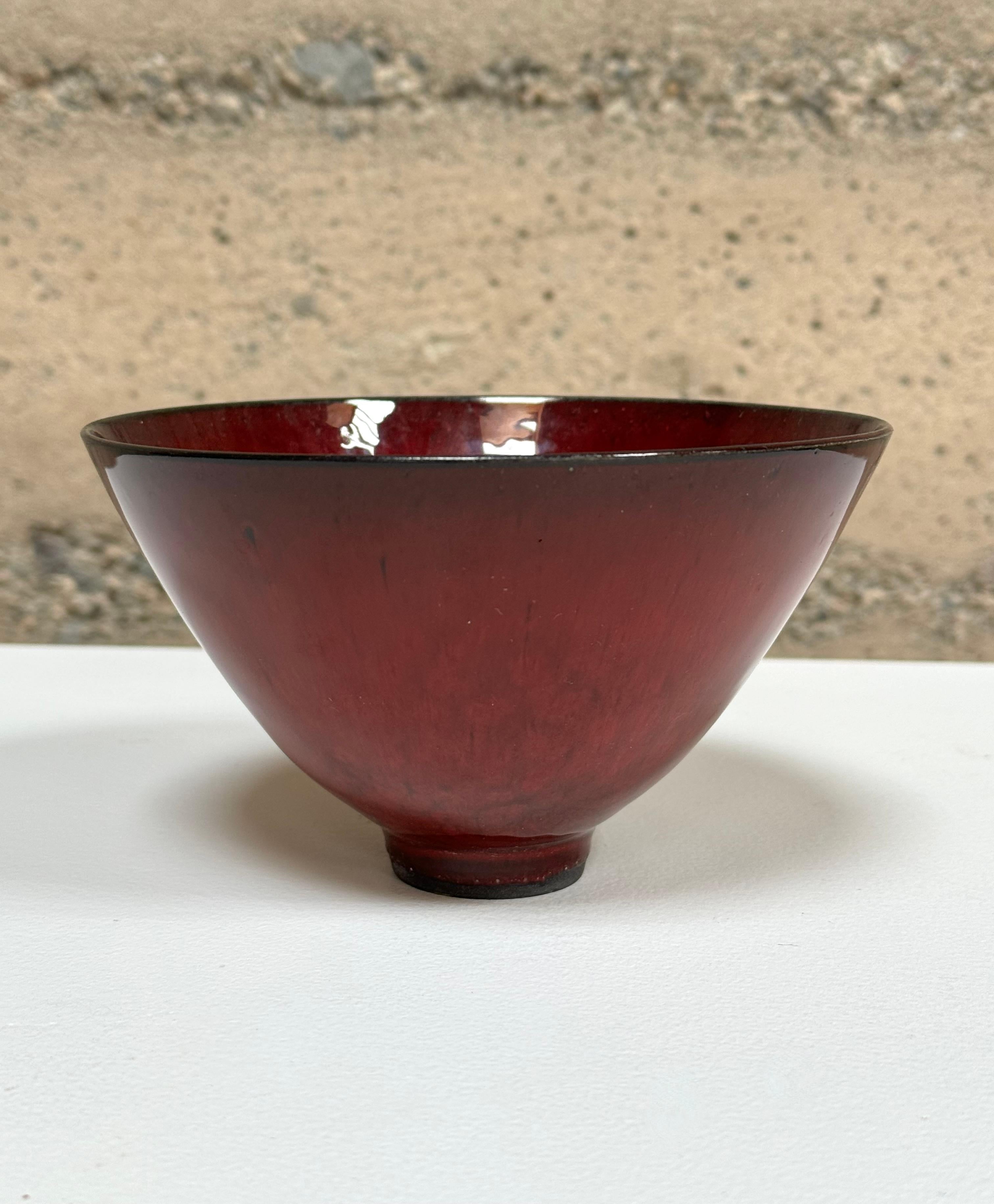 Deep red glaze art bowl by Bay Area artist James Lovera (1920-2015), he was known for his thin walled vessels and bowls with dramatic glazes, this piece those marks. James Lovera’s fascination with the bowl form led him to produce a large focused