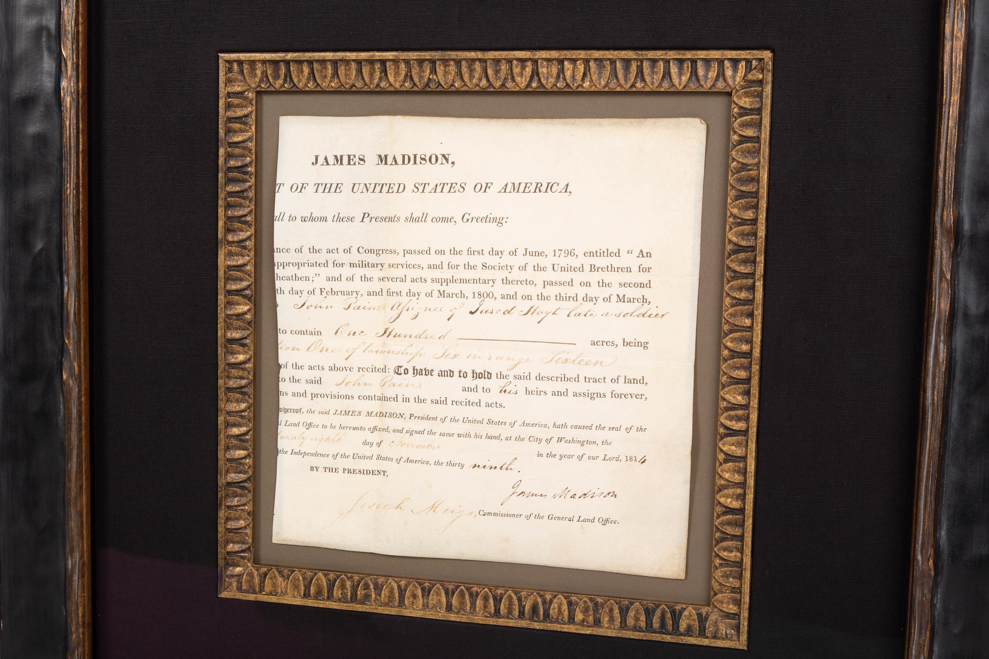 Presented is a custom collage featuring an original signature from James Madison. This collage includes the signed document on vellum, which grants 100 acres of land to John Pain, dated November 28, 1814. James Madison's signature is penned in ink