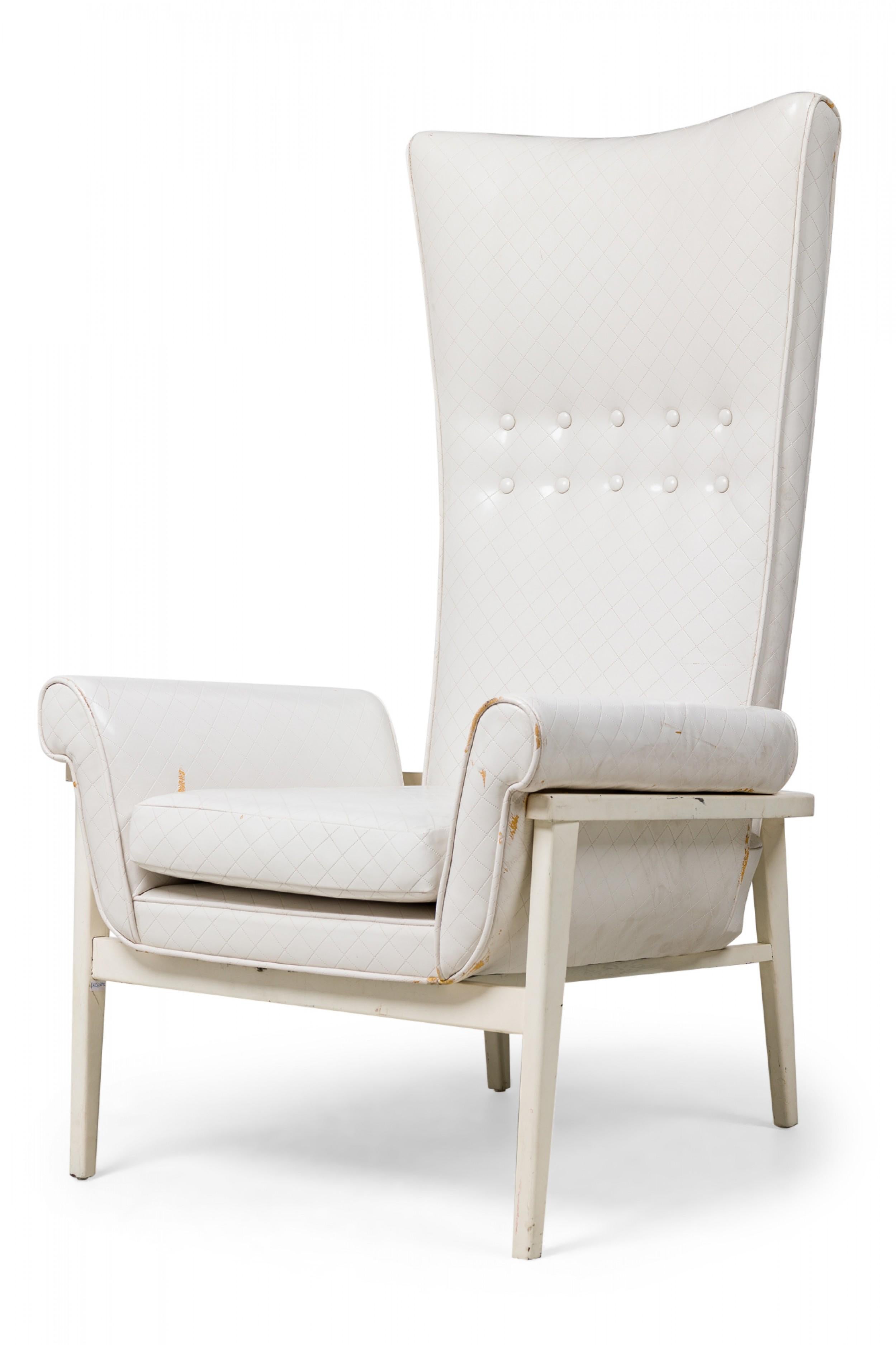 Mid-Century American (1950) lounge / armchair with a high, tapered, button tufted back, curved frame, rolled arms, upholstered in faux white leather embossed with a diamond pattern, standing on 4 tapered square form legs which are slightly splayed.