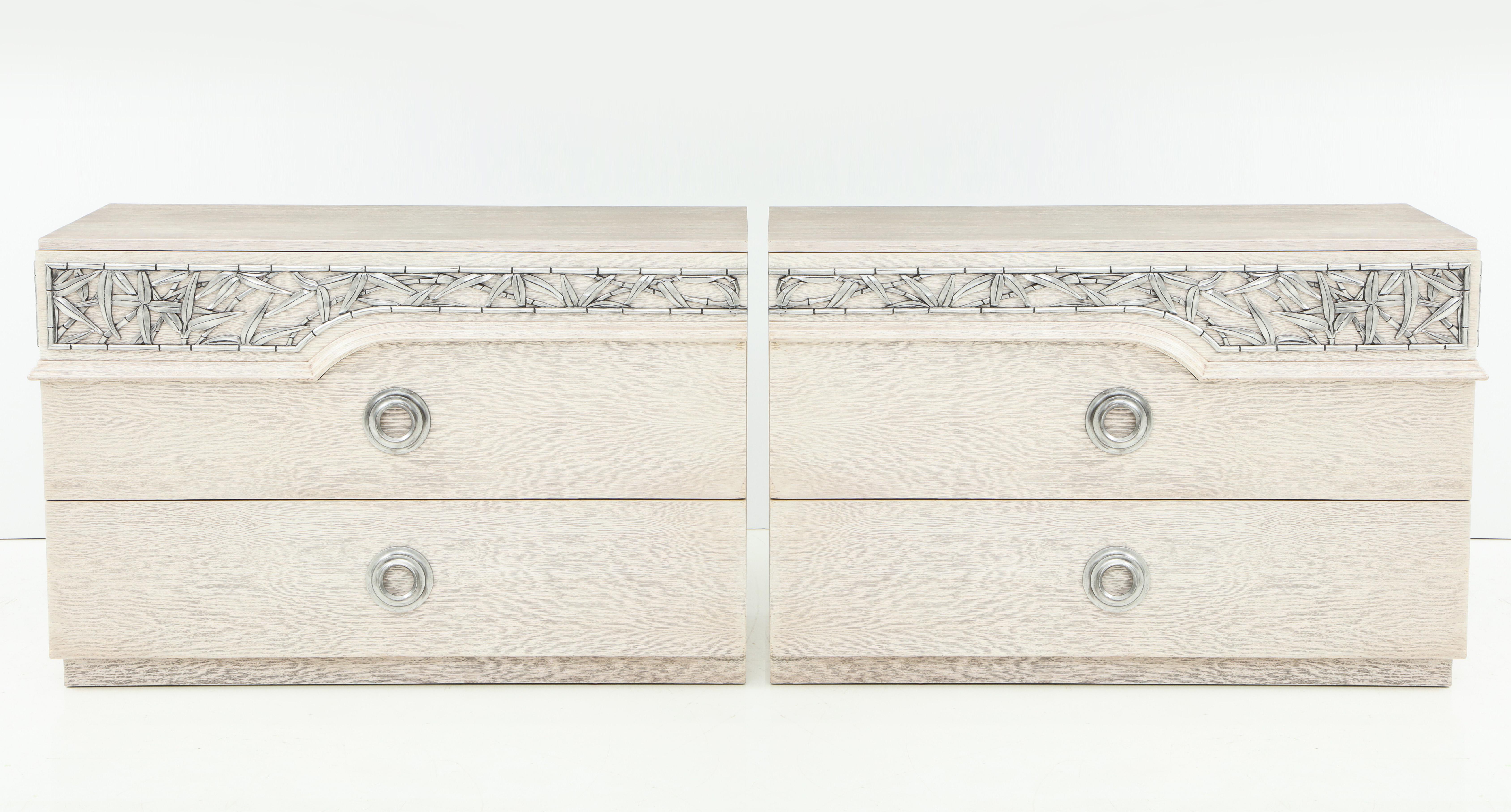 Pareja de cómodas de roble blanqueado/cerúleo en perfecto estado de conservación, con adornos de bambú tallado de inspiración chinesca y acabado en pan de plata envejecido. Diseños estampados de James Mont. 
Cada arcón tiene 3 cajones. Expuesto en