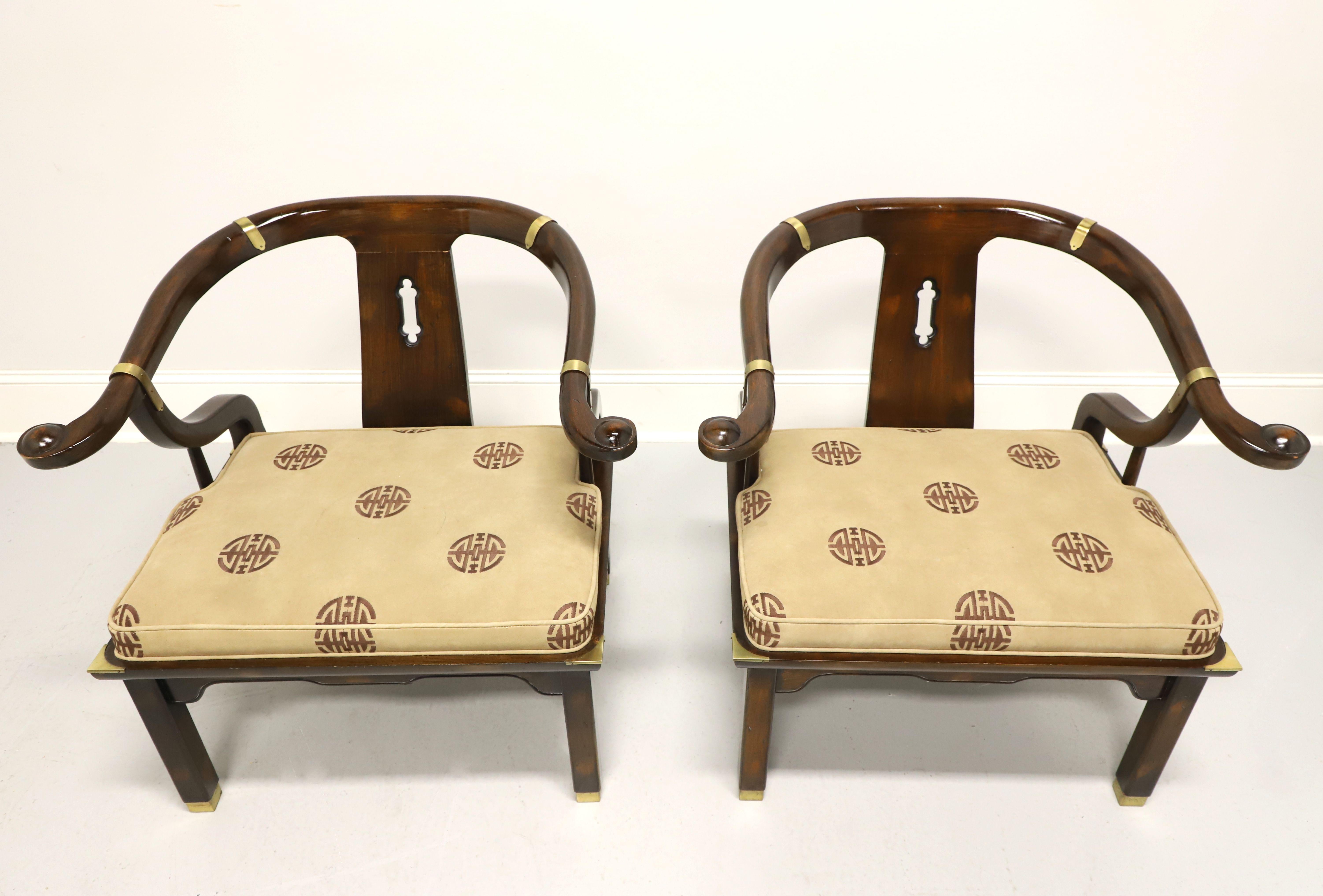A pair of Asian Chinoiserie Ming style horseshoe armchairs in a James Mont design by Century Furniture. Solid wood frame with high gloss lacquer finish, carved backrest, horseshoe shaped arms, carved apron, beige & brown color Chinoiserie print