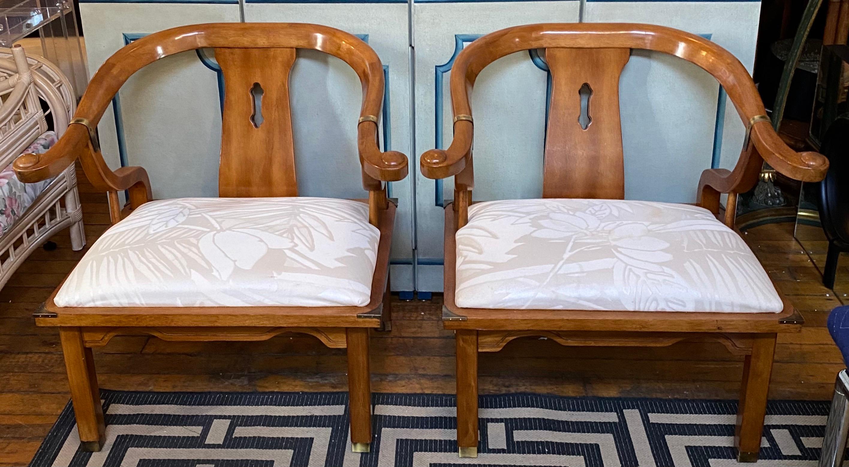 Paire de fauteuils d'appoint en fer à cheval de style James Mont, de style Chinoiserie. Ces chaises de style Hollywood Regency sont dotées de magnifiques cadres incurvés en bois de miel avec des accents de quincaillerie en laiton et des sièges