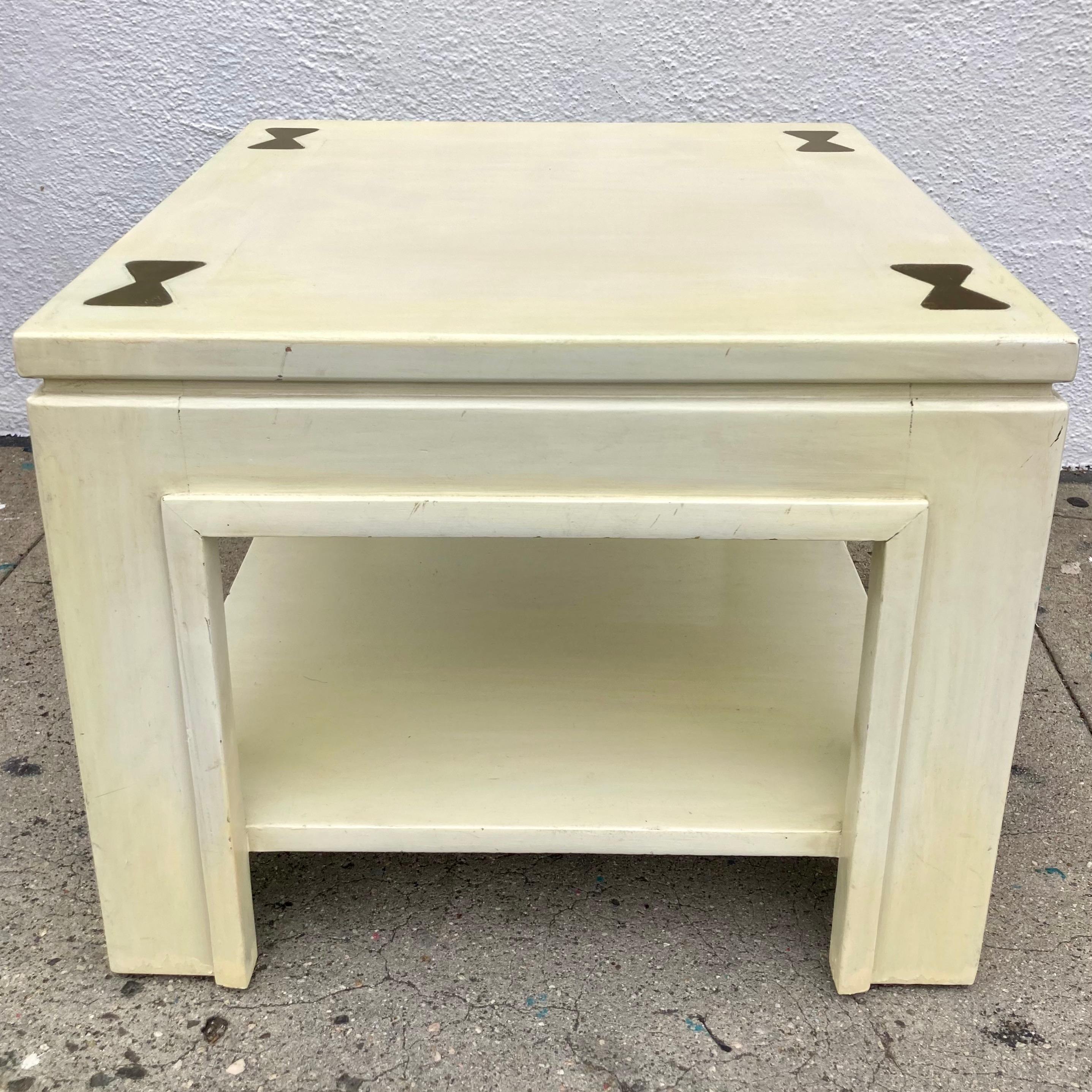 Table de cocktail James Mont de style Ming avec inserts en laiton sur le plateau. Finition peinte d'origine avec des inserts en laiton très uniques et une étagère inférieure. Il s'agit d'une table de cocktail extrêmement rare et nous en avons une