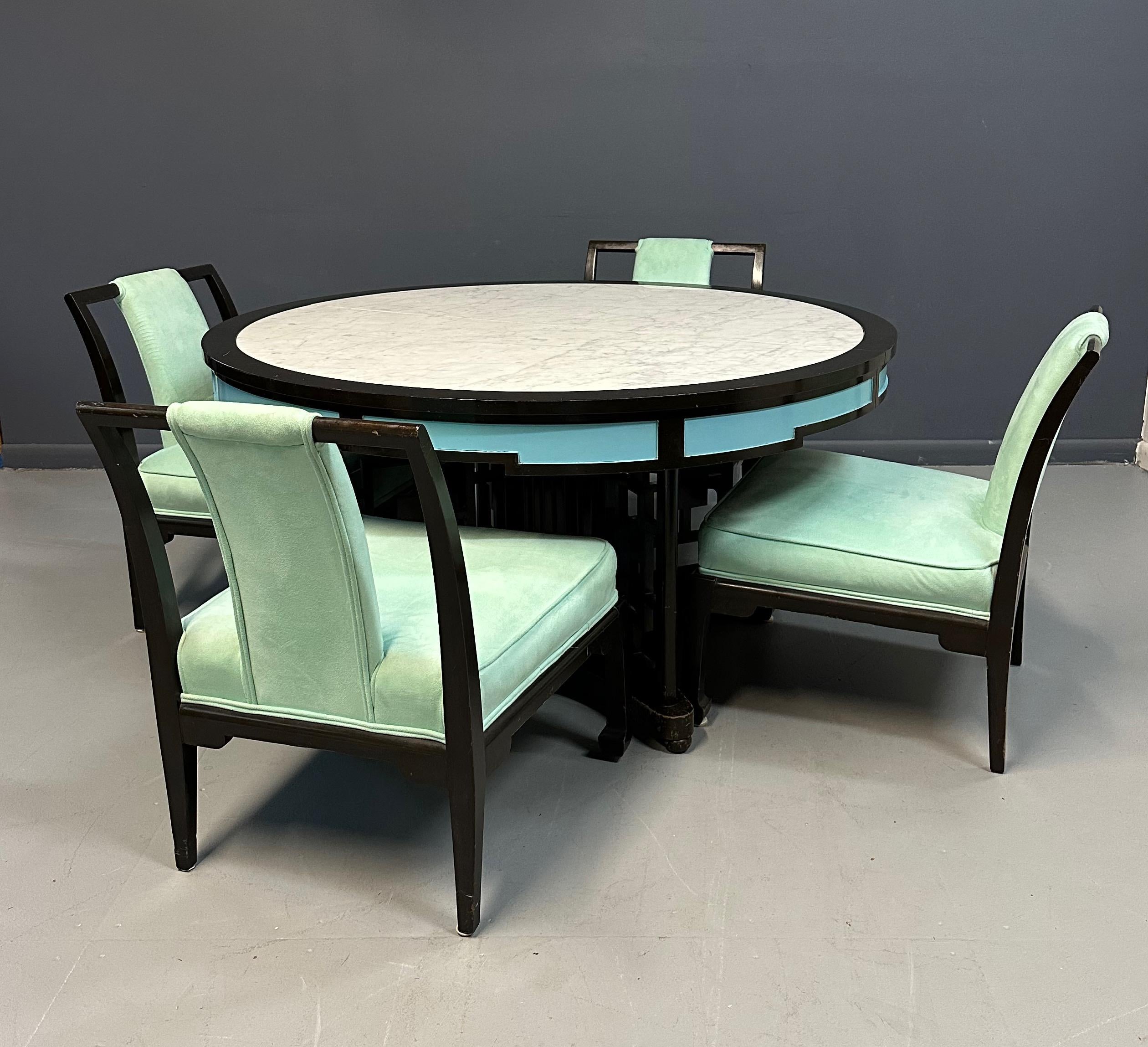Unusual chinoiserie marble topped dining table and four velvet upholstered chairs. The table has a marble inlay and two leaves. The chairs have been upholstered in a lovely sea foam green and the side panels on the table have been painted that