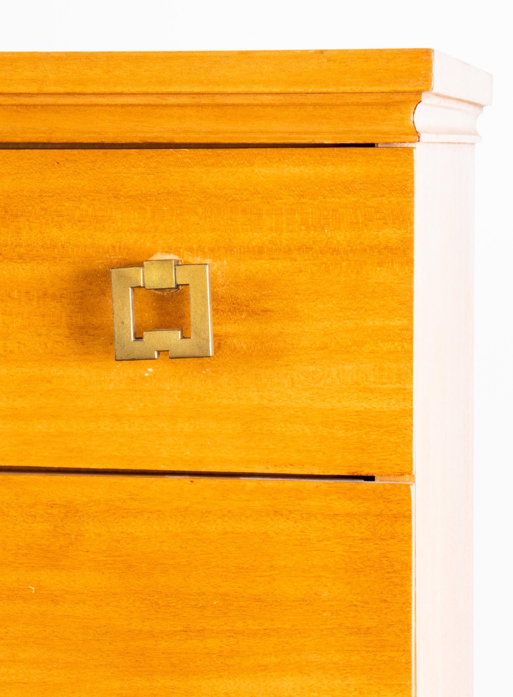 Mid-Century Modern five-drawer blonde wood dresser, in chinoiserie or James Mont style, with geometric brass hardware and cutout base, the lower drawer with covered compartment. Measures: 47