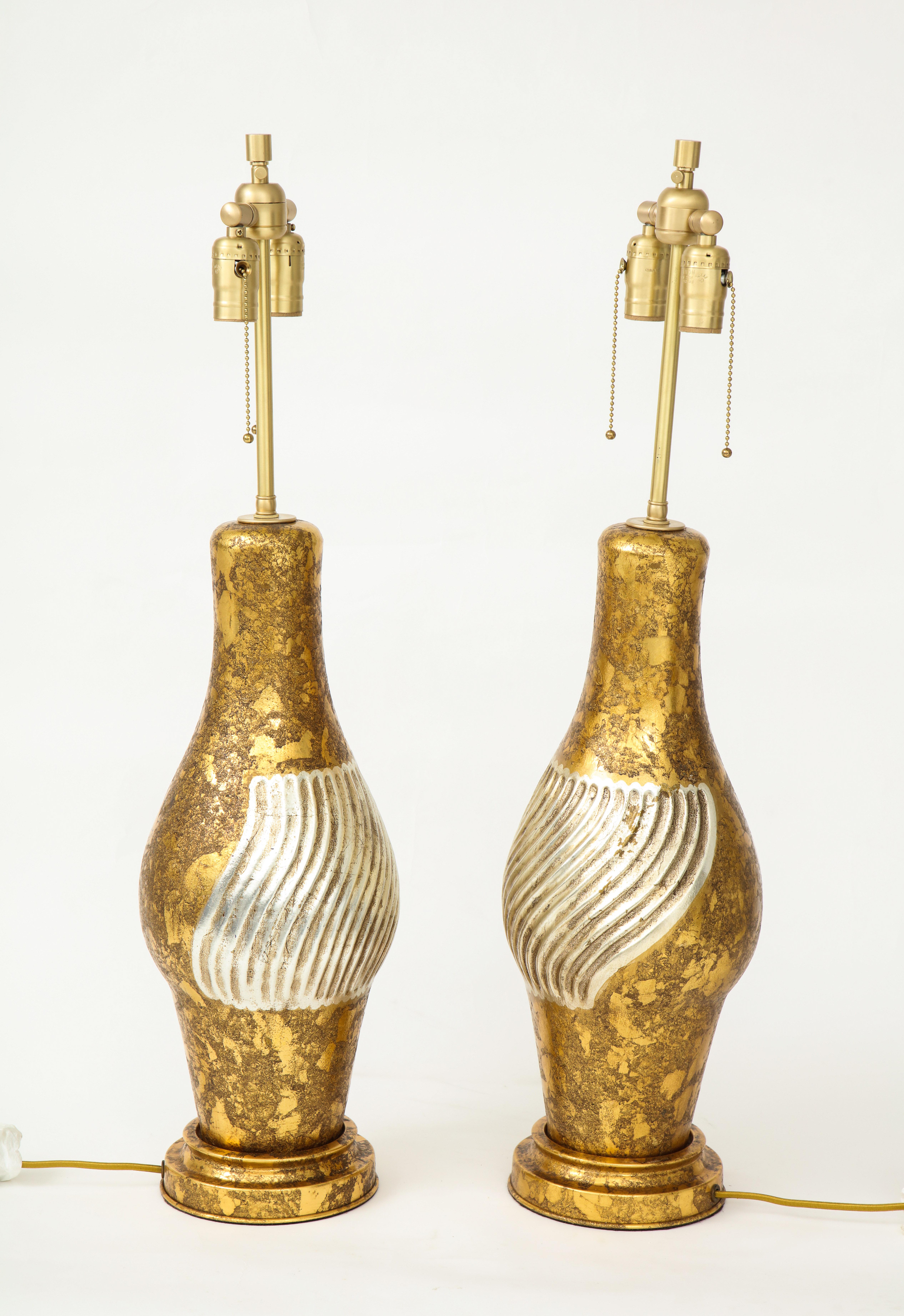 Pair of large scale, James Mont influenced, gilded porcelain lamps with silvered section. Lamps have been rewired for use in the USA with brass pull chain sockets. 75W max each unless using LED bulbs.