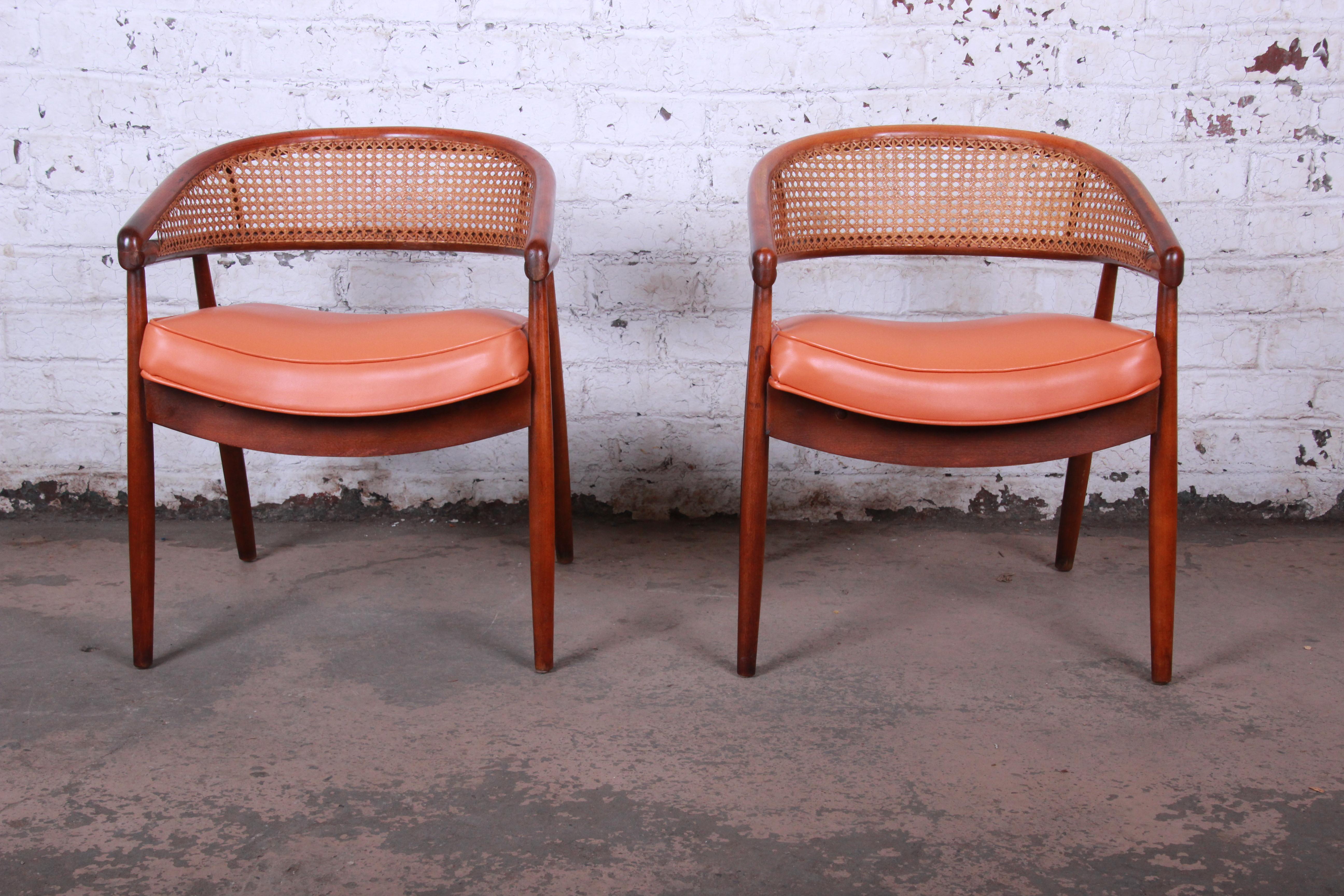 An exceptional pair of James Mont style bent beech wood and cane back club chairs. Mont famously used this design in Nat King Coles' Miami Penthouse project. The chairs feature a stunning bent wood design and original orange naugahyde upholstery.