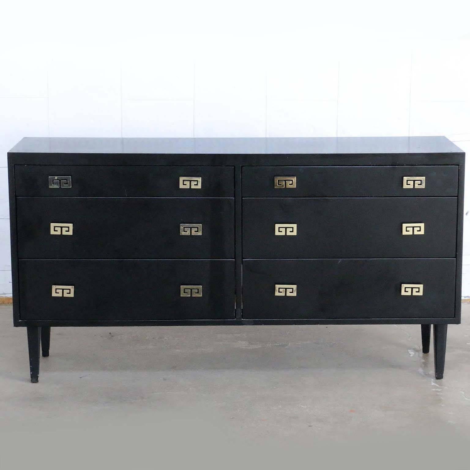 Elegant Mid-Century Modern ebonized six-drawer dresser or chest of drawers made in the manner or style of James Mont. Produced by Woodland of California featuring a black finish with decorative brass metal pulls with a Greek key motif. The dresser