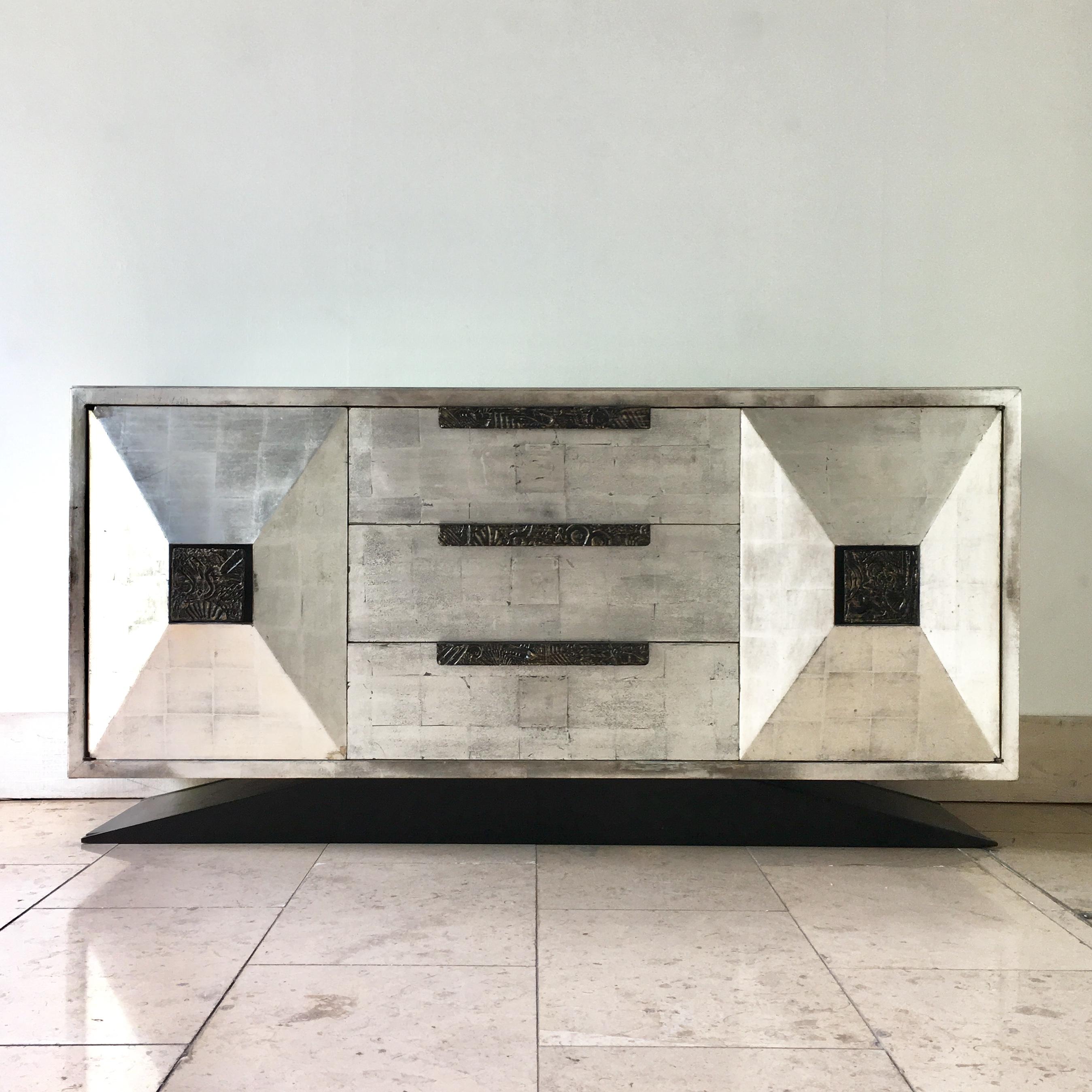 A James Mont style Silverleafed cabinet with custom made Brutal sculpted bronzed resin handles after Paul Evans USA 1950s, Talisman Edition

This cabinet is a superb example of Talisman's skill of reinterpreting an original Mid-Century Modern