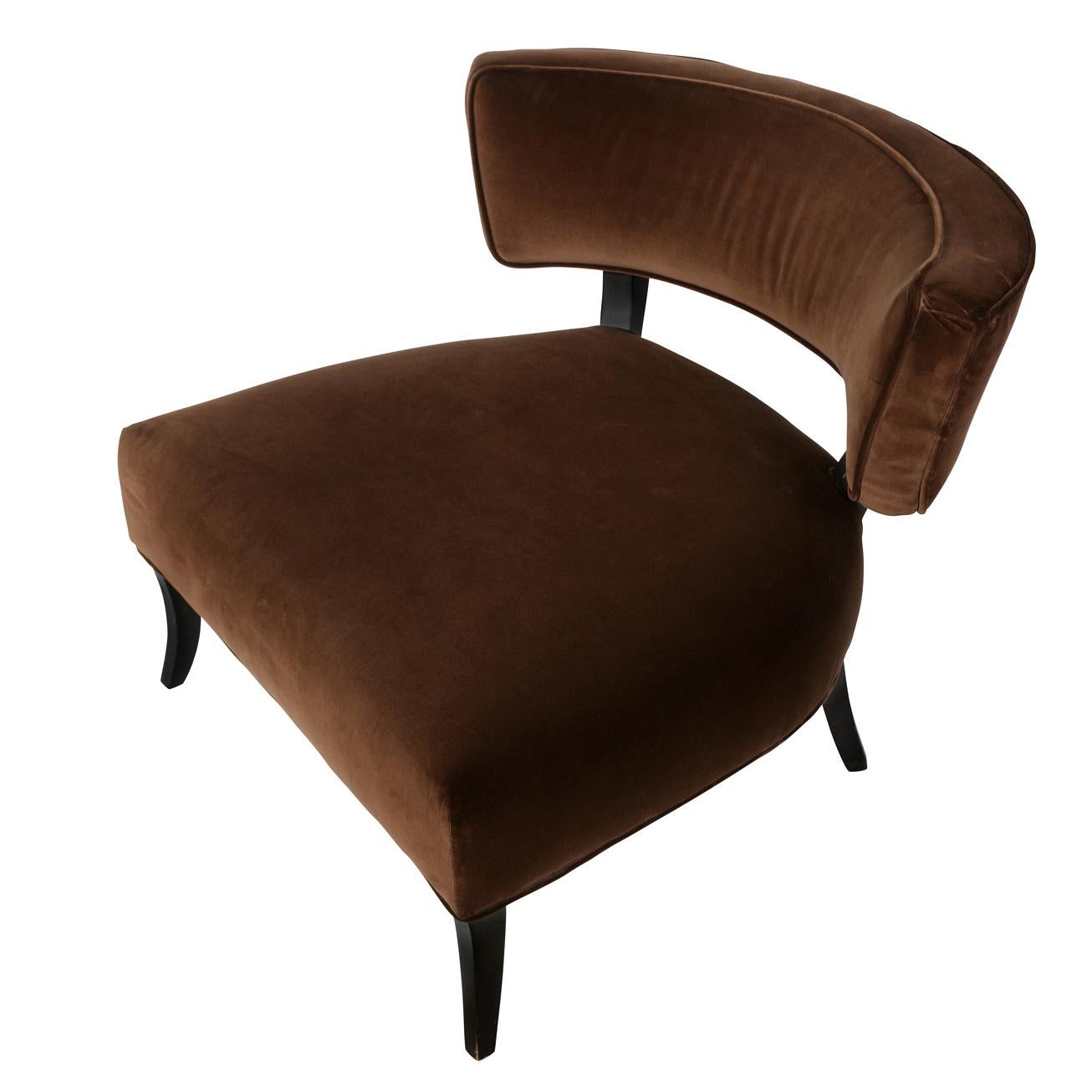 A vintage curved brown oversized chair in James Mont style with wood legs and velvet upholstery.