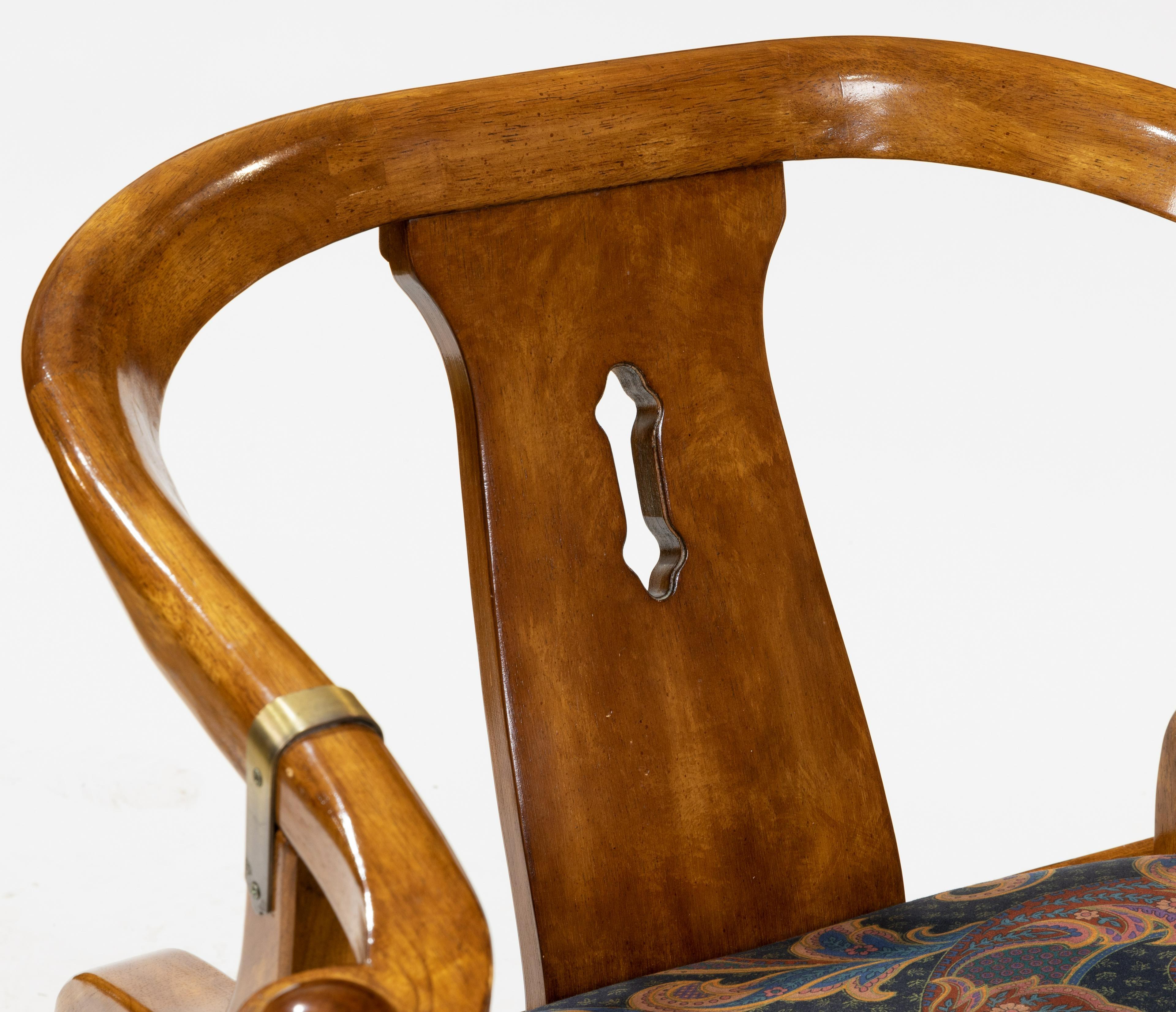 James Mont style horseshoe chair made of wood with brass fittings and upholstered seat.