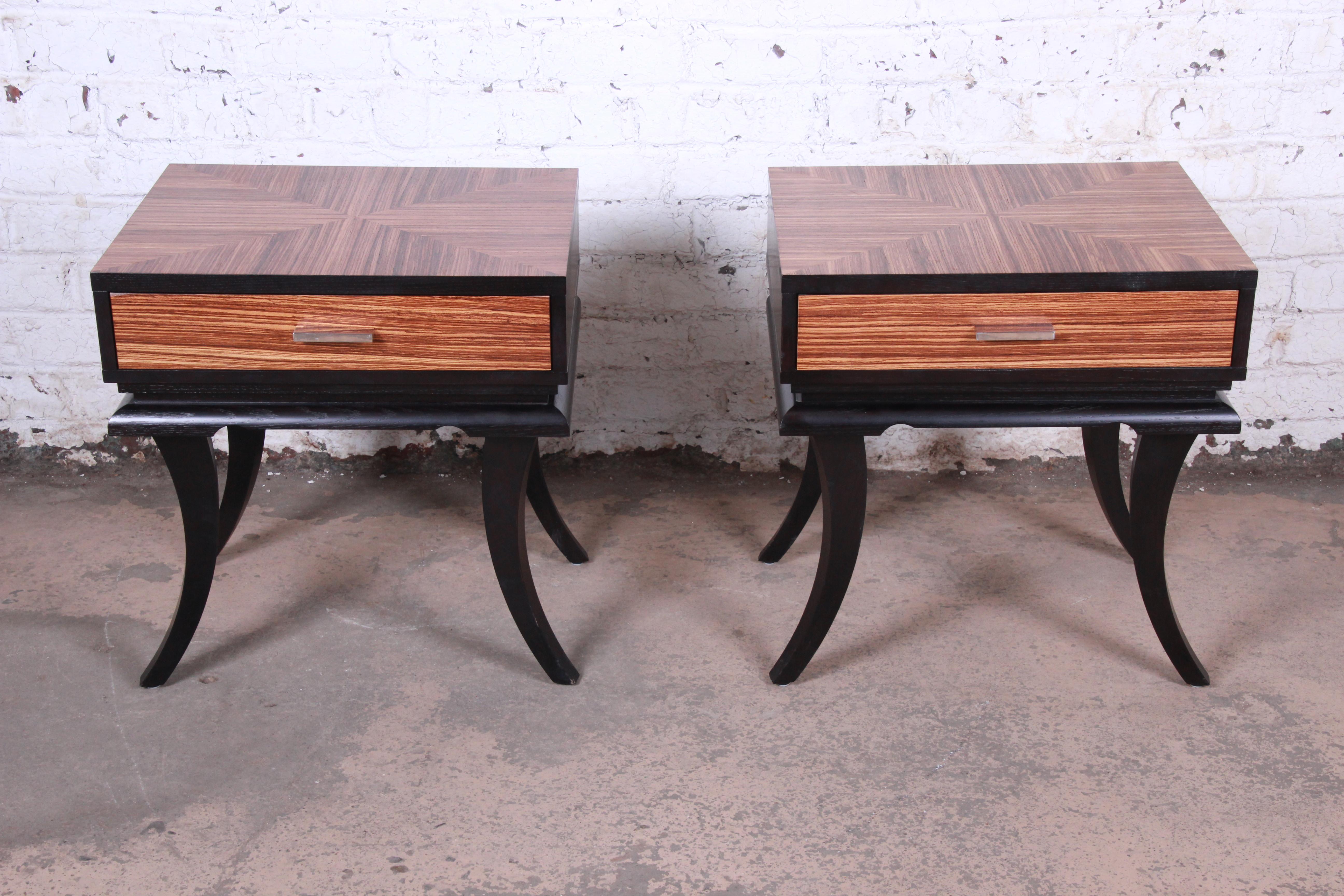 A gorgeous pair of James Mont style saber leg nightstands

USA, late 20th century

Inlaid zebrawood tops and drawer fronts + ebonized wood + chrome hardware + leather drawer inserts

Measures: 24