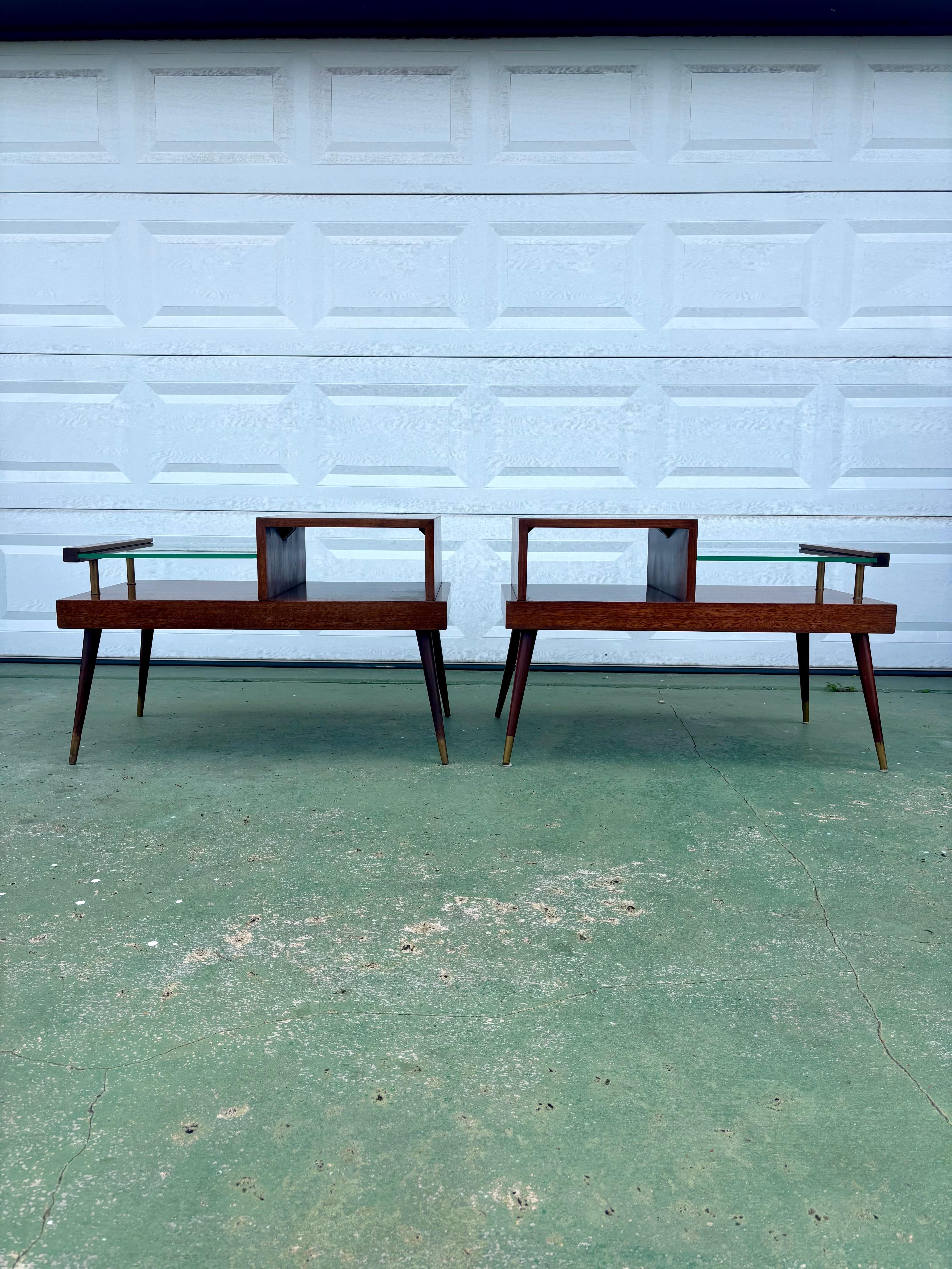 Pair of James Philip co side tables in original finish. 

Draped in their beautiful original mahogany veneer. These tables offer an interesting yet clean classic mid century modern silhouette. A multi tiered table with a .5” coke bottle glass top