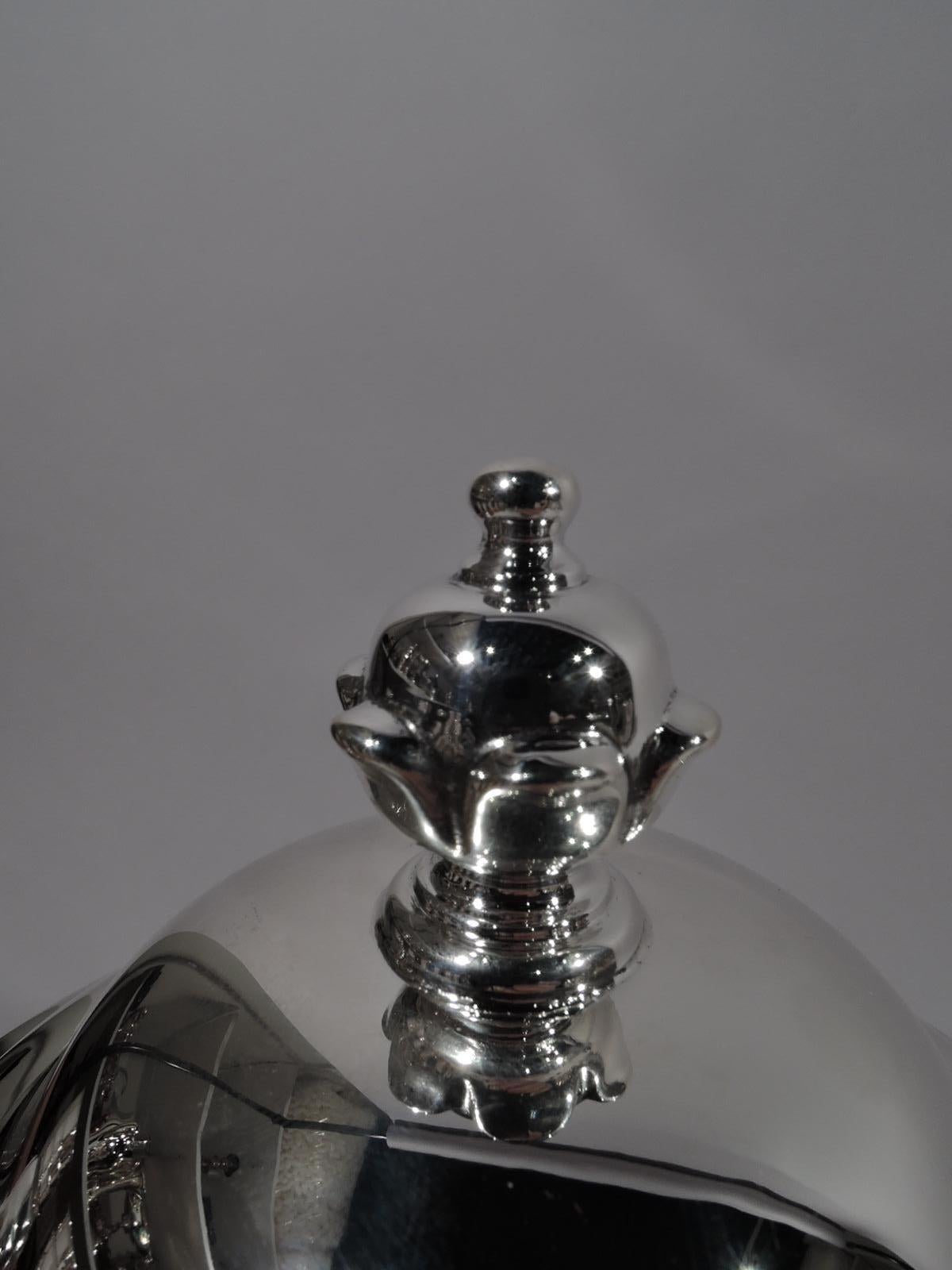 Classical sterling silver covered urn. Flying double-scroll side handles and domed foot. Cover double-domed with bud finial. A traditional trophy with lots of room for engraving. Marked “James Robinson / Sterling / 1”. Weight: 31.5 troy ounces.