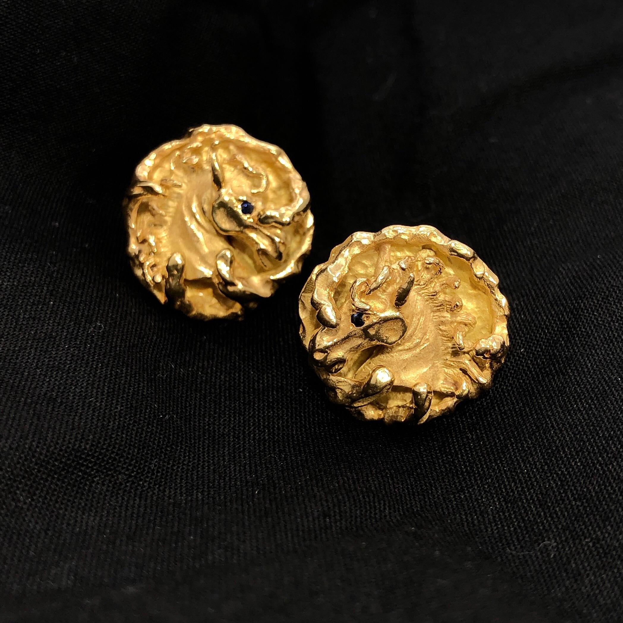 These lovely 18k gold cuff links weighing 42.2 grams and  created in the USA are an excellent example of the powerful depictions characteristic of 1960's design. Each link features a gorgeous horse head with rich blue sapphire eye surrounded by free