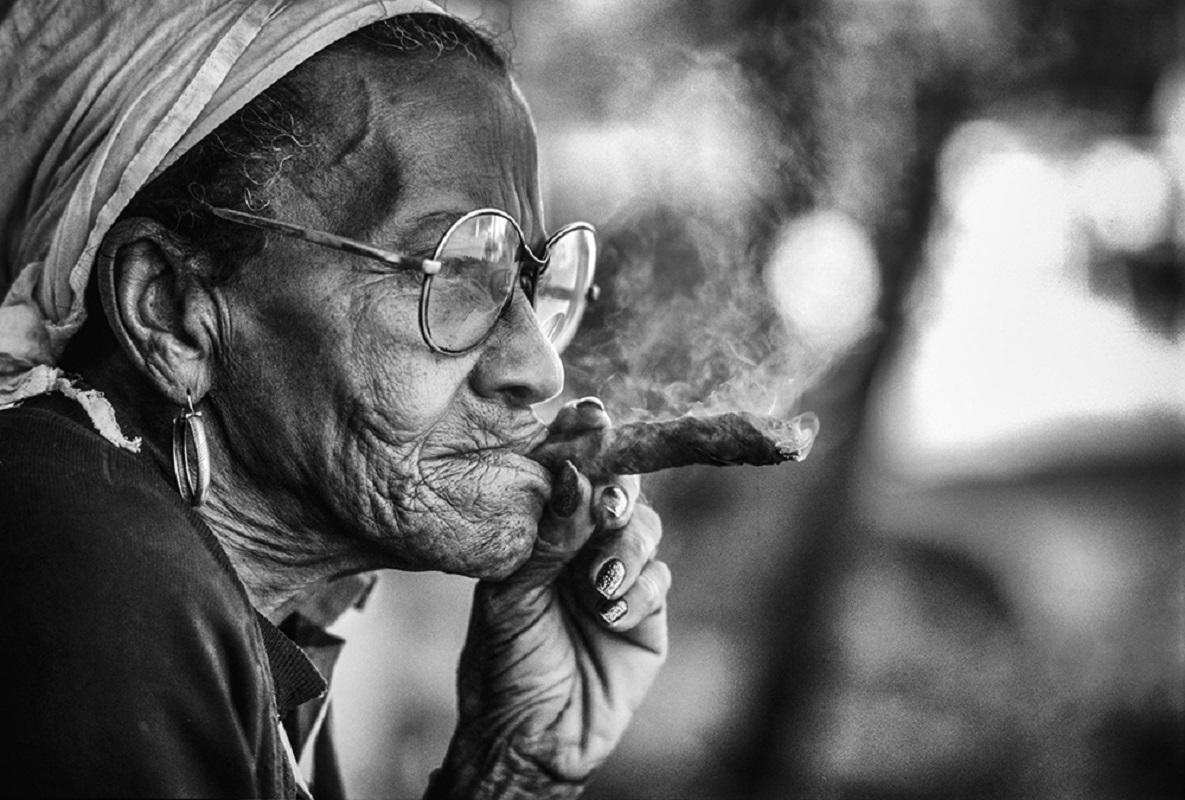 Las Memorias… sitting on a rocking chair in Viñales watching the sunset and thinking of life.

The wife of a tobacco farmer, a strong woman of generosity and humour lost in thought while enjoying a hand-rolled Puro and a glass of rum.

Available as