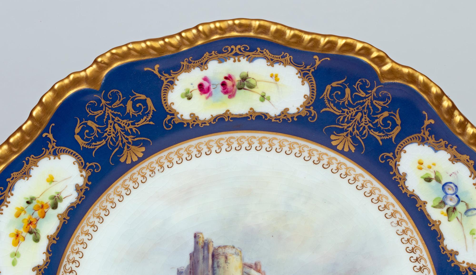 A stunning Royal Worcester porcelain cabinet plate hand painted with a scene titled Castle of Doune by James Stinton and dated 1933. The plate has a central scene of the castle set in a landscape within a decorative border with small floral