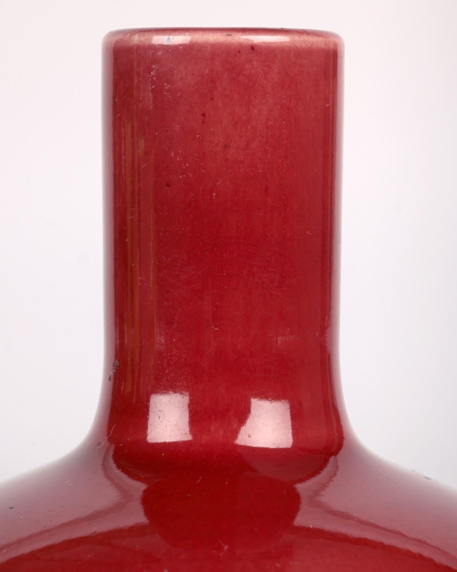 A stylish Arts & Crafts small bottle shaped vase, in the manner of Christopher Dresser, decorated in red Sand de Boeuf glazes by renowned potter James Wardle and dating from around 1890.

The vase is part of a private collection of Arts and Crafts