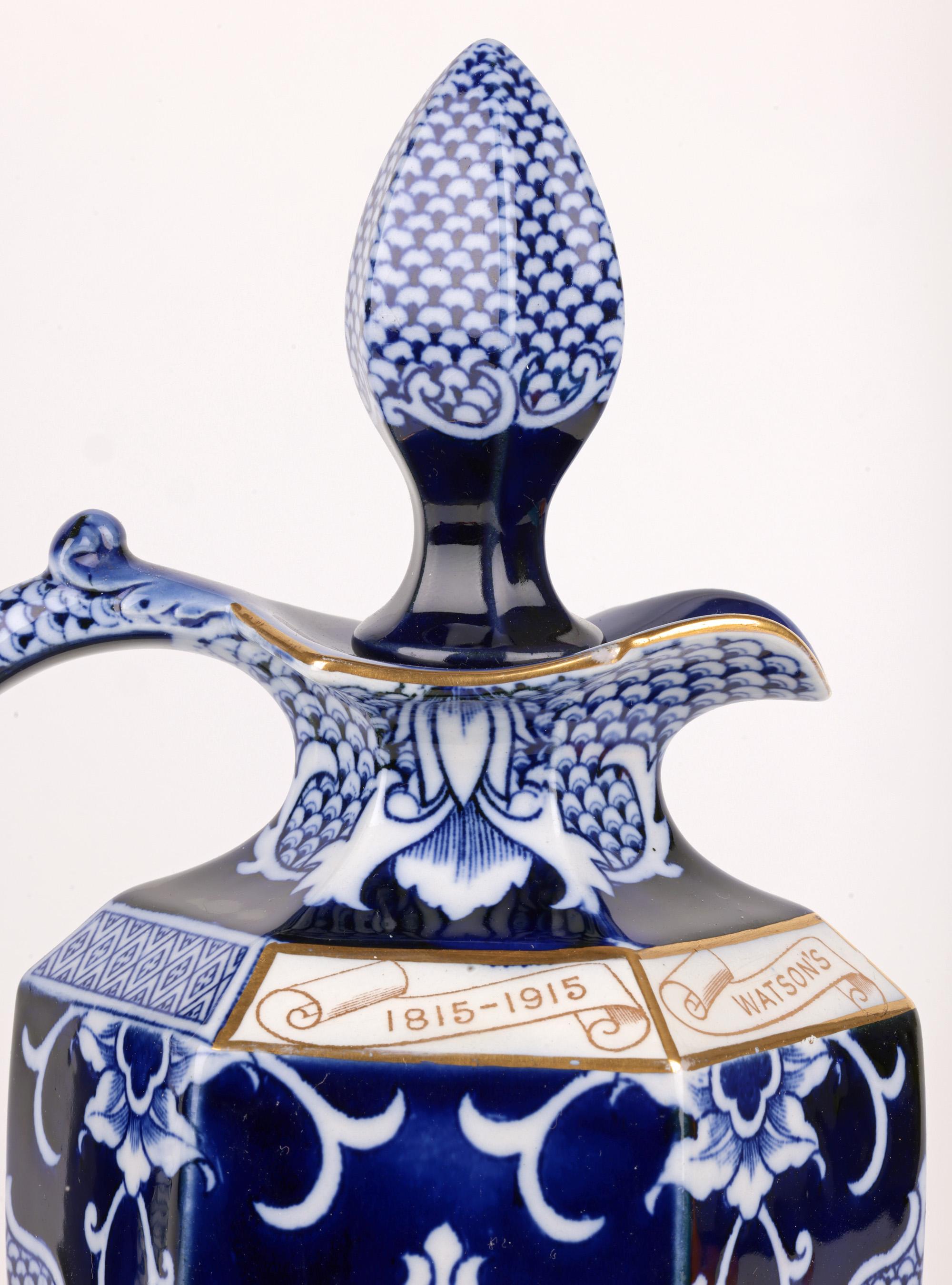 A very fine Art Deco George V and Asquith commemorative Whisky flask made in Staffordshire for James Watson, Dundee and dated 1915. The tall ceramic flask of hexagonal form is lightly made and stands on a narrow hexagonal foot with a widening body,