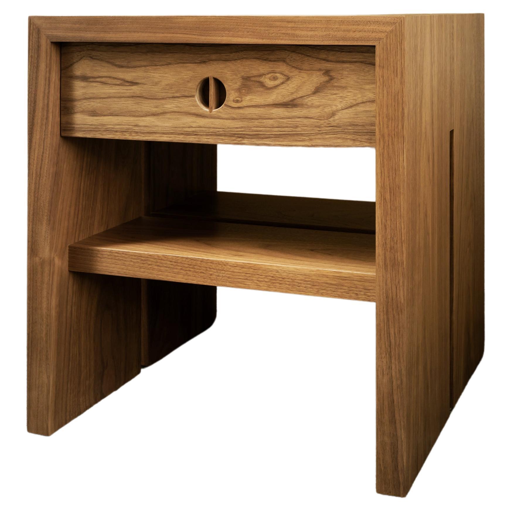 This custom nightstand with drawer is hand-made in the United States with all hardwood construction. Characterized by its striking waterfall design, unique split leg detail, and convenient and accessible storage drawer and shelf, the minimalist