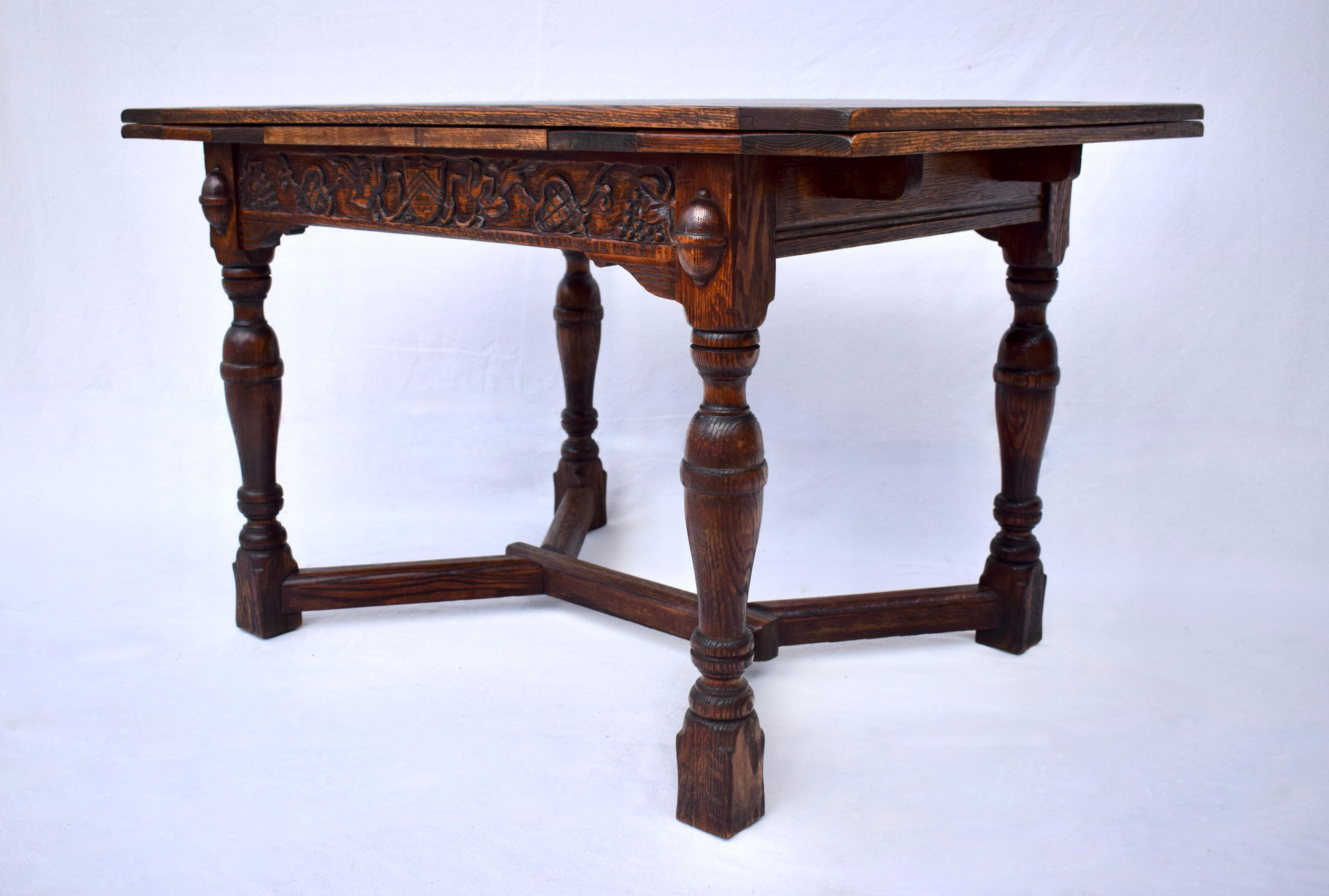 A.I.C., début du 20e siècle. Table de salle à manger de style Jacobeon en chêne massif Tiger avec 2 allonges. Nous aimons la largeur plus étroite et polyvalente, les grains de bois flamboyants et les sculptures exquises de fruits de la récolte et de