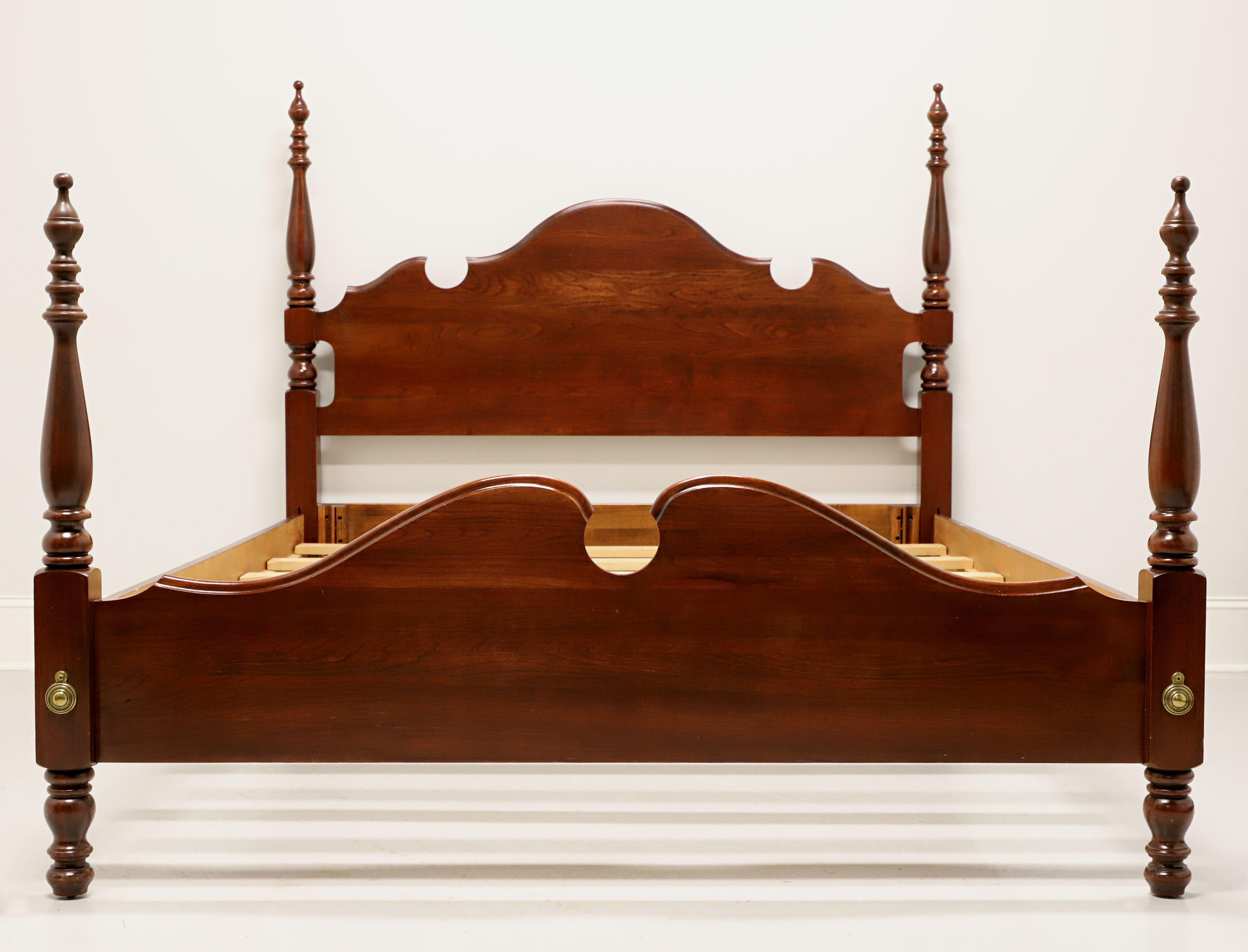 A Chippendale style queen size short poster bed by Jamestown Sterling. Cherry with carved top to headboard, a shorter footboard with carved top, four turned posts with finials, brass hardware, metal clip held side rails, and six wood slats for