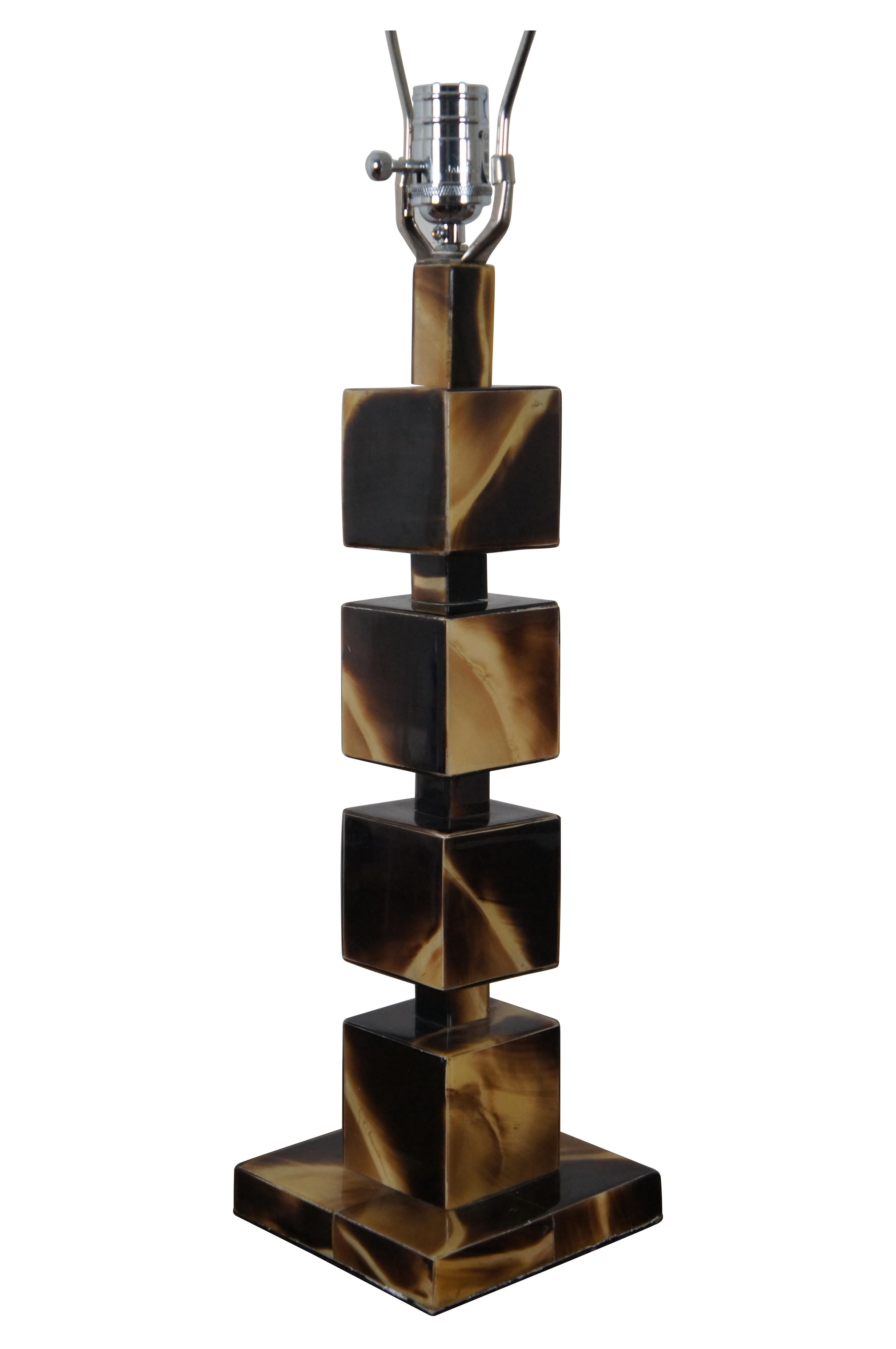 Lampe de table géométrique vintage Jamie Young en corne acrylique présentant une pile de cinq cubes / blocs sur une base carrée.  Comprend une harpe et un embout rectangulaire noir.

Dimensions :
6