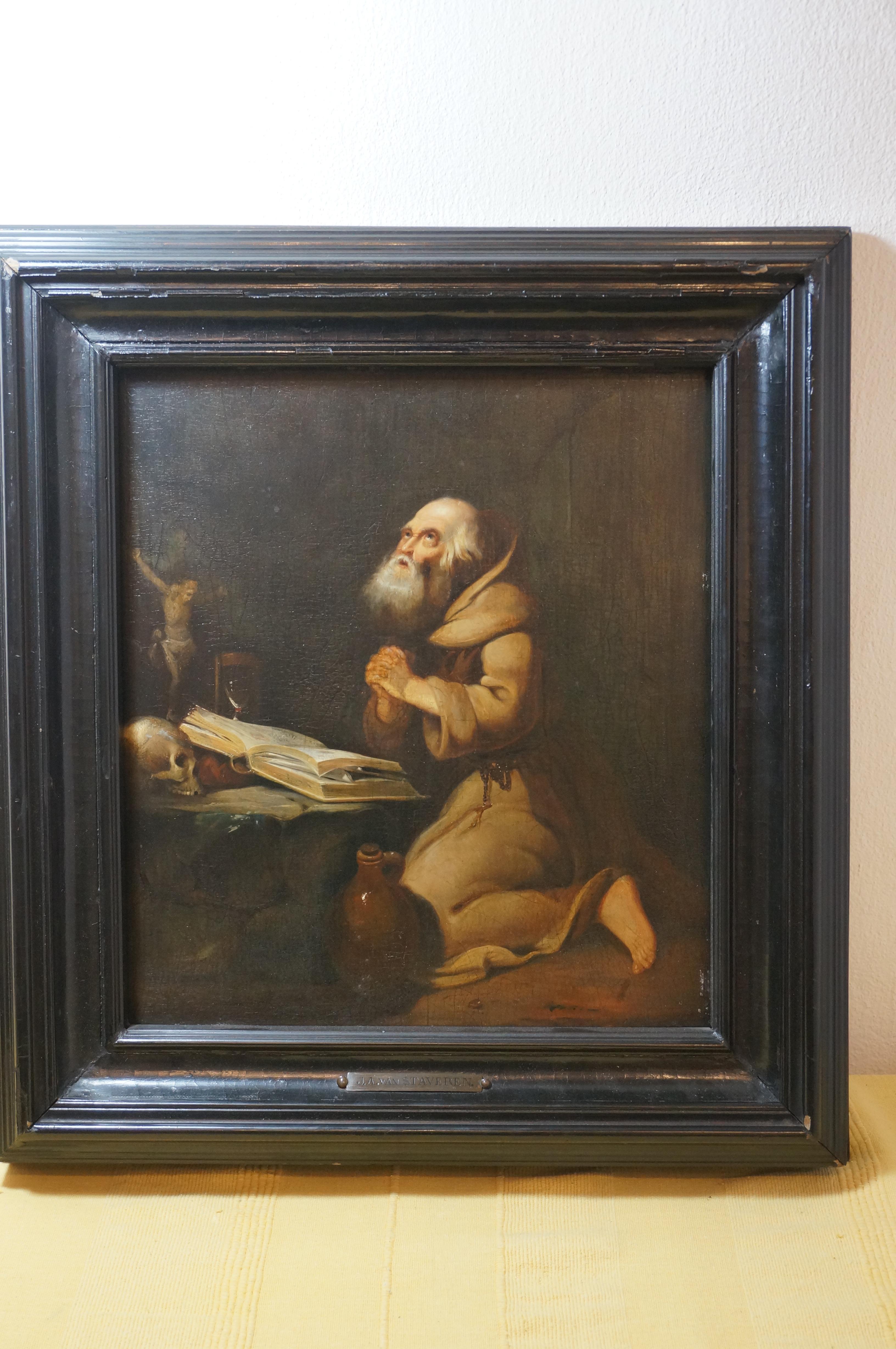 Painting of a praying hermit with book ( bible), skull (Memento Mori), Cruxifix with Corpus Christi, Rosary, Waterjug and Hourglass (Tempus Fugit = use your time well).

Oil on a bevelled oak panel. Follower of the 'Leiden painters'.

Black frame of