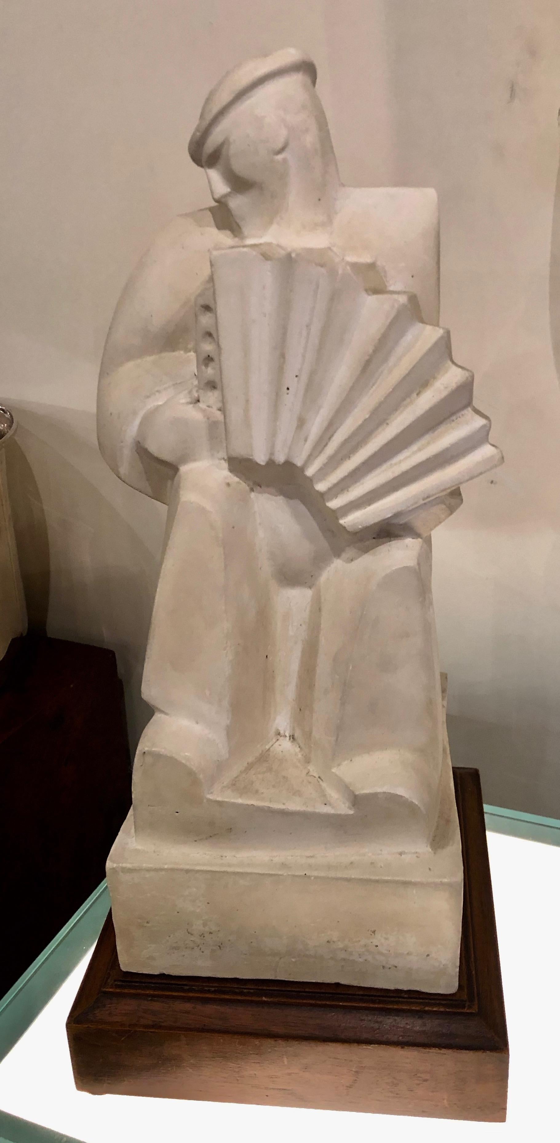 Jan and Joel Martel “L’Accordioniste” The Accordion Player. in cast stone sculpture with painted wood base France, circa 1925. One of the most important sculpture by these brothers, it was done it many different materials, bronze, wood, cast stone.