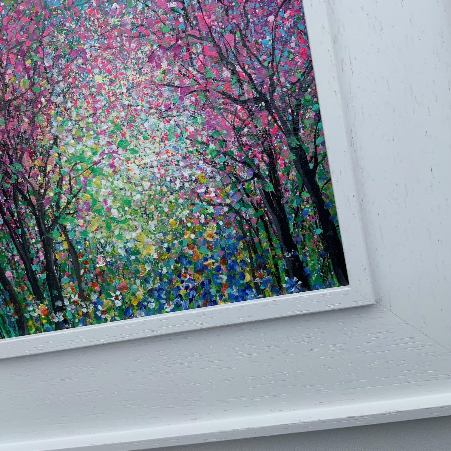 Florecer en Elnup II de Jan Rogers es un pequeño cuadro enmarcado a medida. Un marco profundo de madera lavada en blanco que resalta la colorida escena del bosque con cerezos en flor en todo su esplendor. Pintada con acrílicos dorados y sellada con