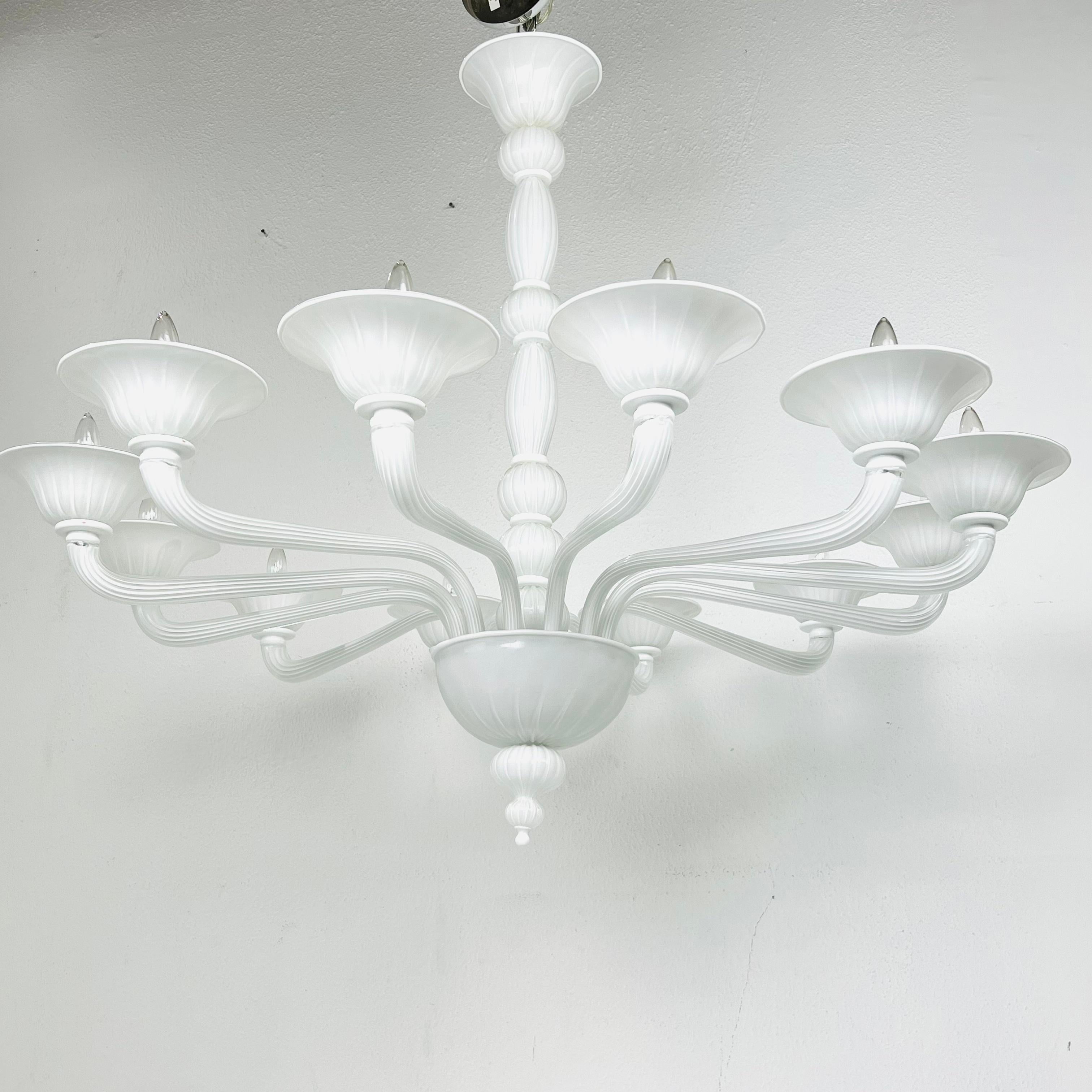 Large scale hand-blown Murano glass chandelier from Jan Showers. This gorgeous chandelier features a central column connected to a lower basket from which 12 graceful, curved arms emerge to hold large cup shades. Interesting scale and shape and
