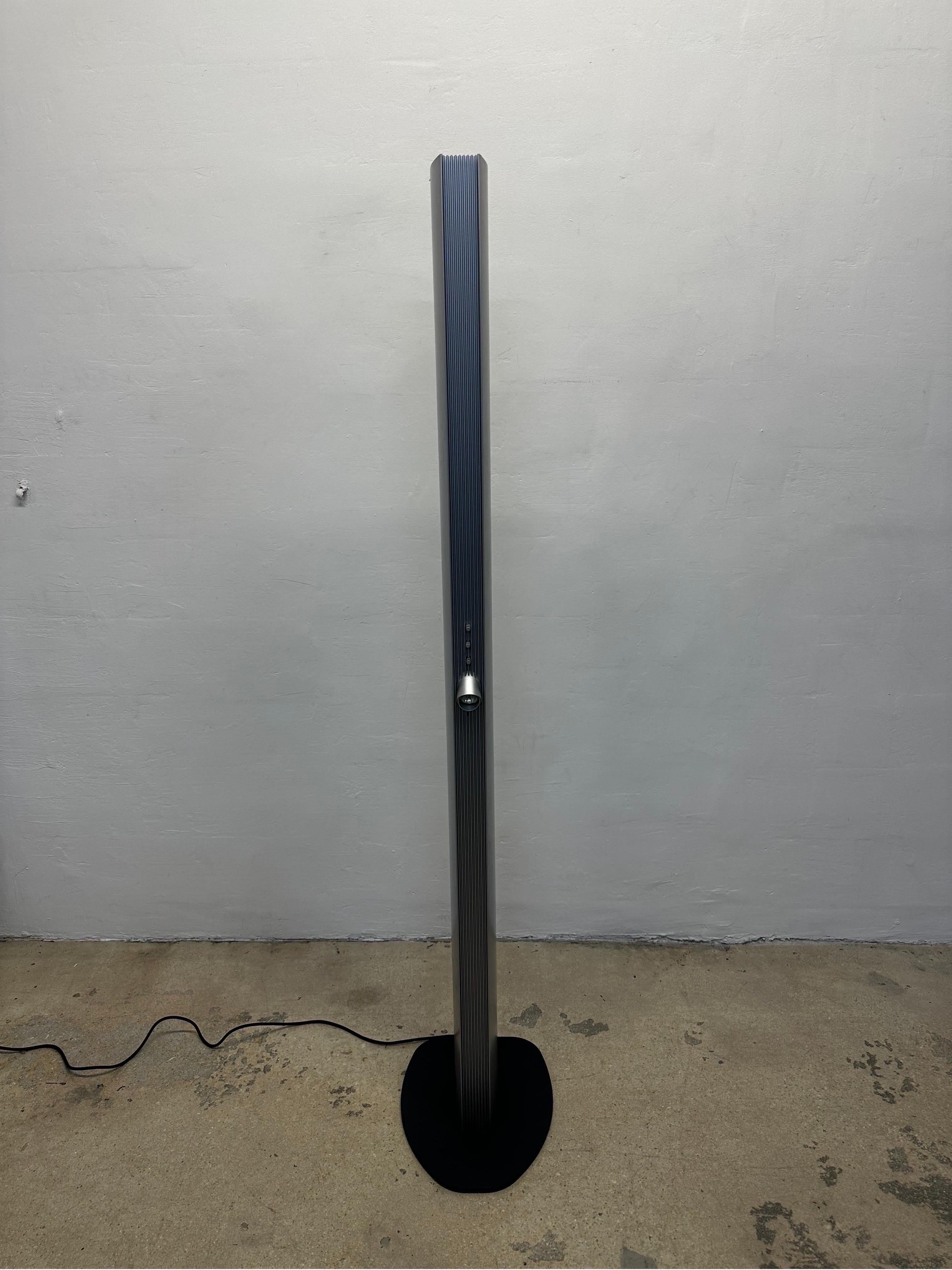 Echos floor lamp designed in the 1980s by Jean Van Lierde and produced by Artemide. The sculptural tower lamp features three separate light sources; halogen at the top, a dimmable swivel spotlight in the middle and a long fluorescent tube on the