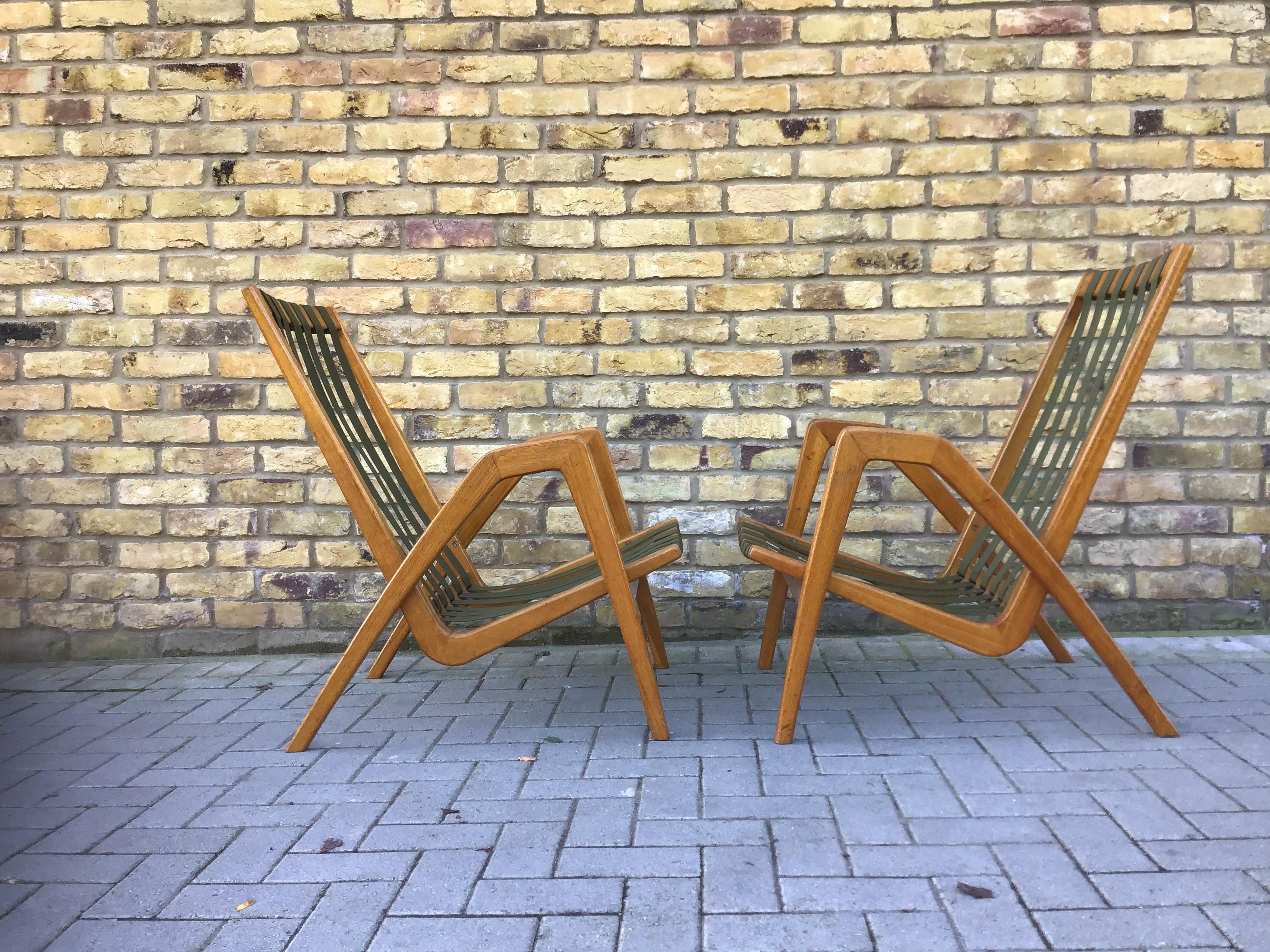 Delicious pair of armchairs with fantastic shaped wooden frame in oak.
Designed by architect Jan Vanek in 1950s. All in good condition with 
Original fitted cushions to show off the detailed design of the chairs.
For Krasna Jizba Cc Czech