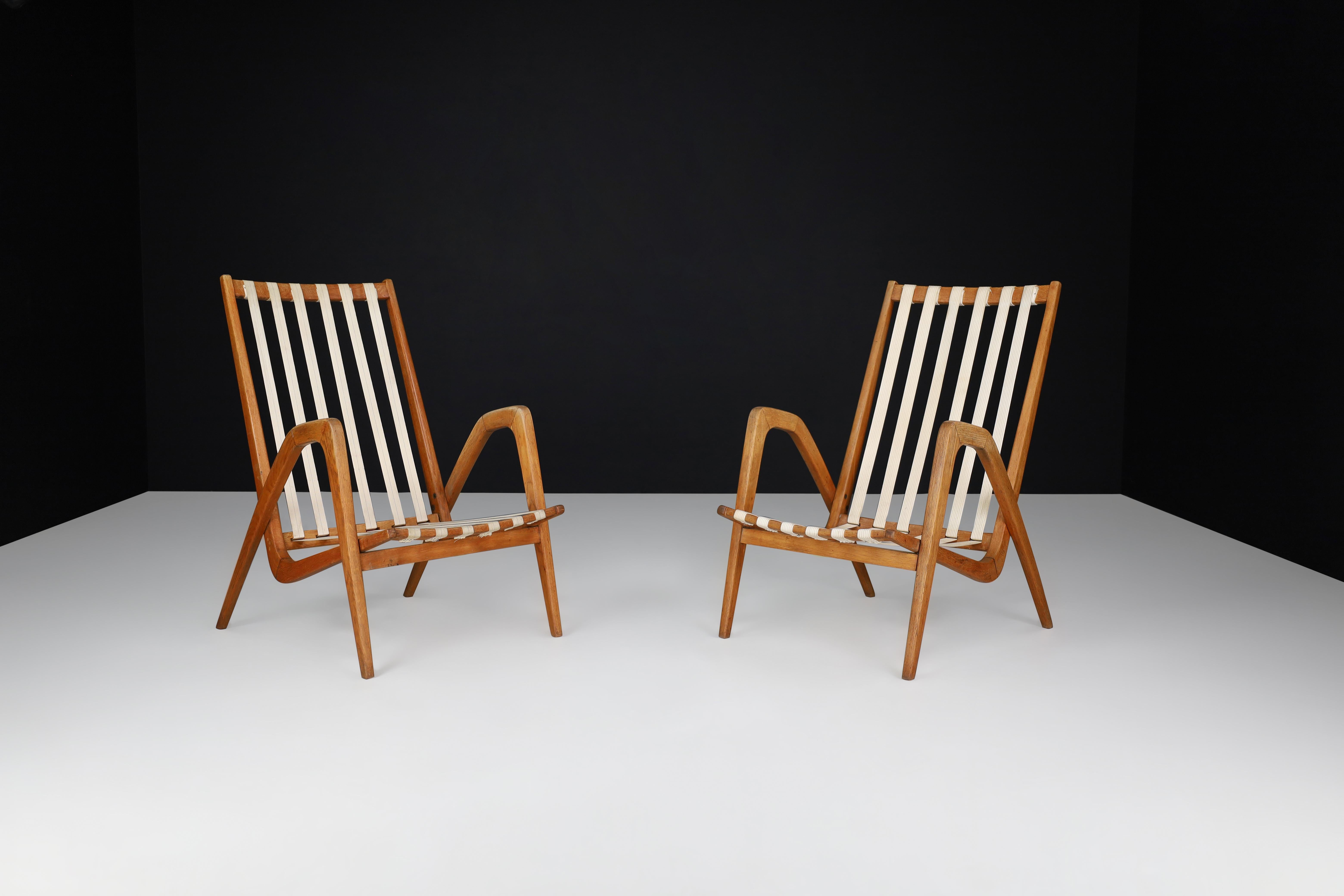 Jan Vanek Oak Lounge Chairs, 1940s

Sculptural lounge chair in oak and linen straps designed by Jan Vaneck in the 1940s. The gentle corners of the frame repeated in the armrests make this set look sculptural and have a simplistic, functional